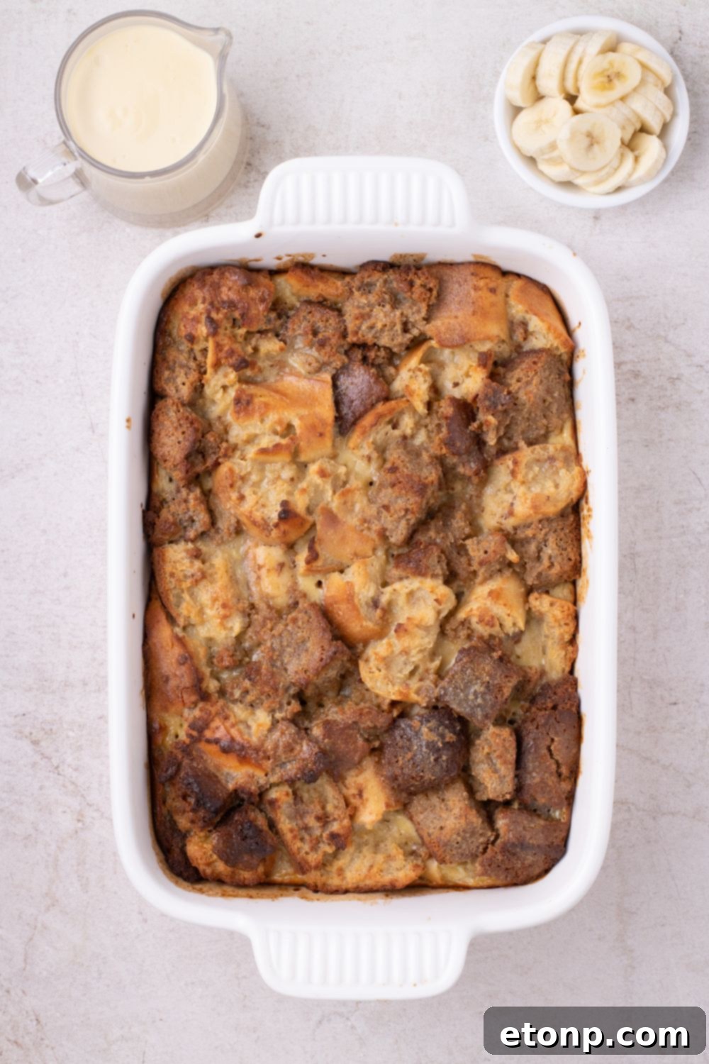 baked Banana Bread Pudding in a casserole dish on table 