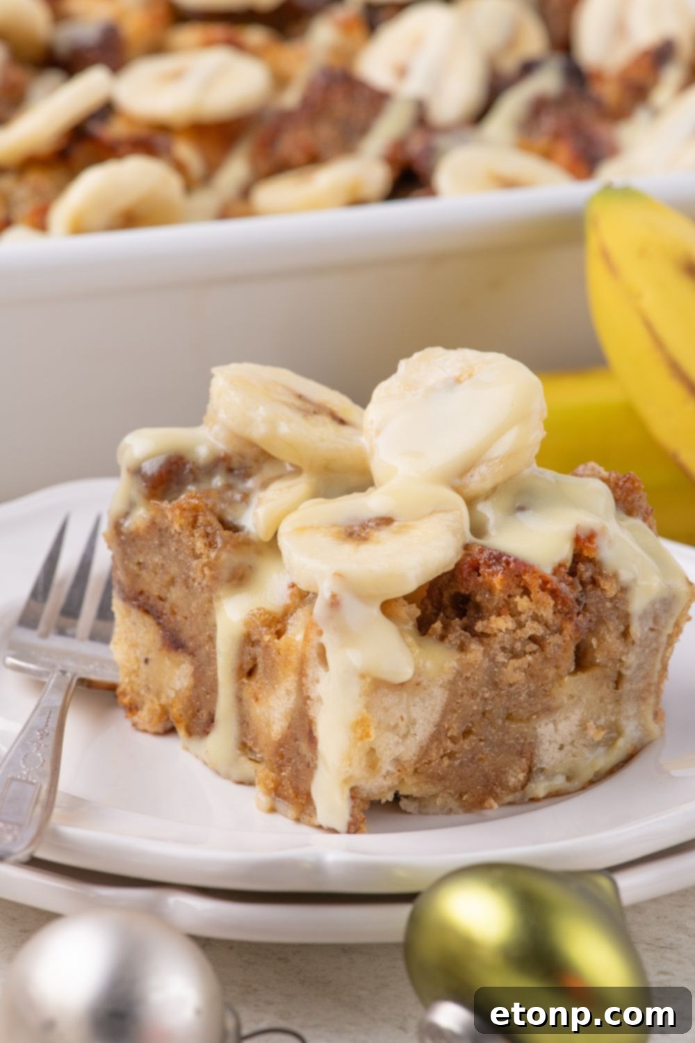 double stacked plate with a slice of Banana Bread Pudding on it with a fork on the side 