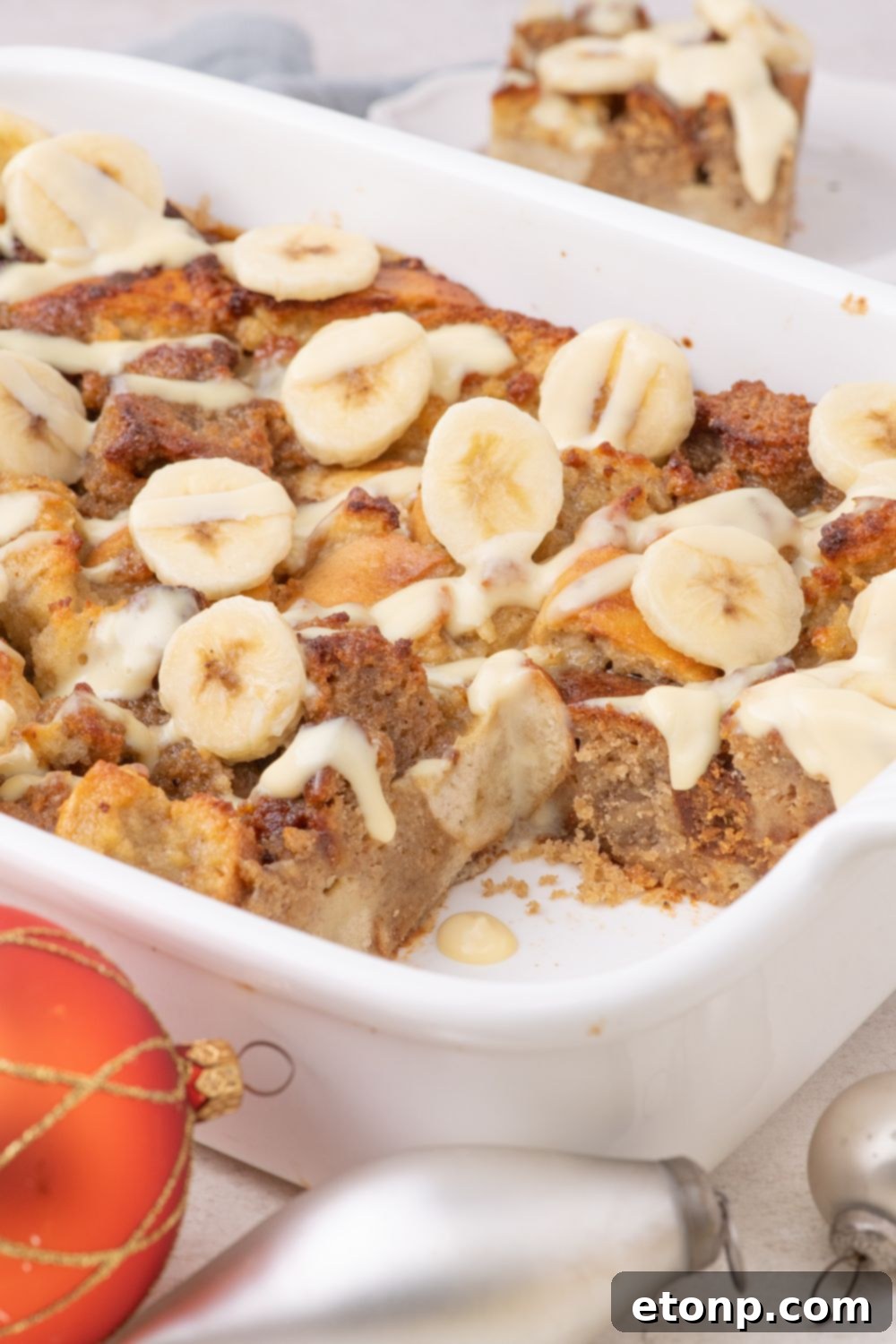 side view of Banana Bread Pudding in pan with a slice taken out of it 