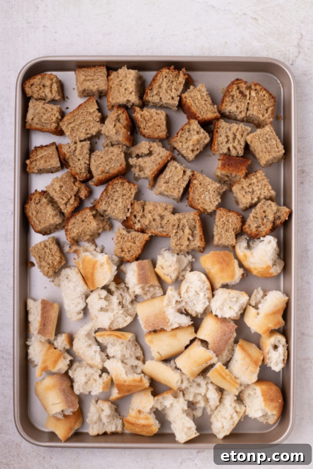 sheet pan with diced bread and banana bread cubed for making Banana Bread Pudding