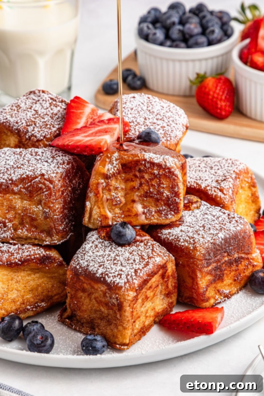 a generous drizzle of syrup over Hawaiian Roll French Toast on a beautiful platter