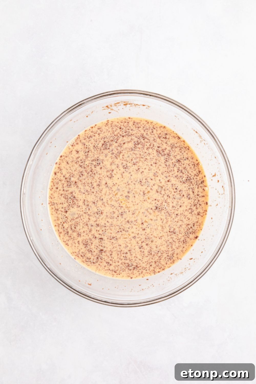 creamy egg custard mixture in a clear glass bowl, ready for French toast dipping