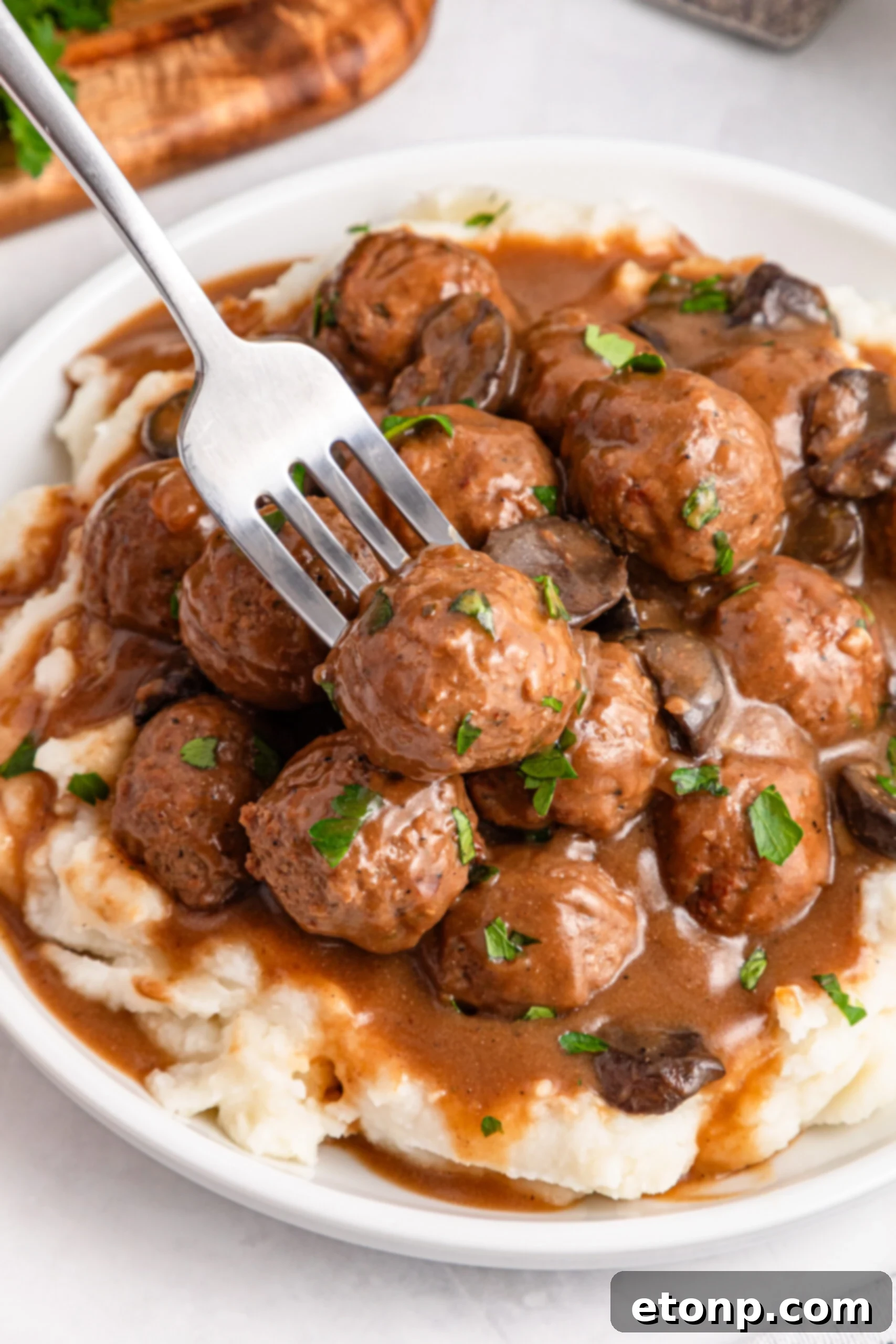 Comforting Slow Cooker Salisbury Steak Meatballs 2 Crock Pot Salisbury Steak Meatballs on a plate with mashed potatoes under them with a fork on the side