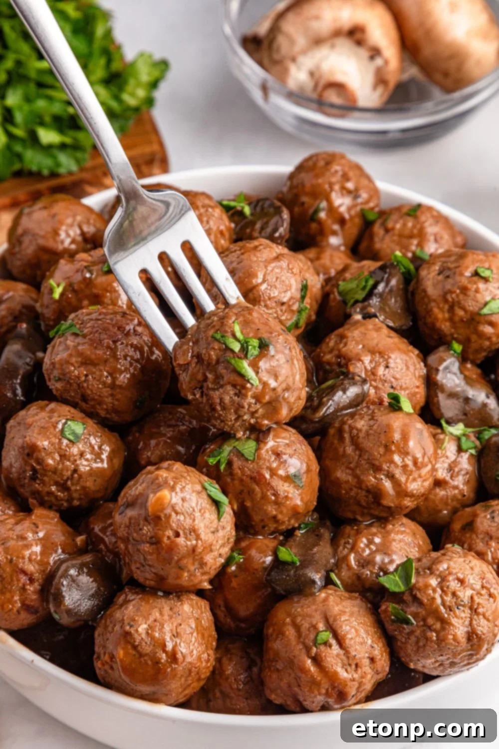 Comforting Slow Cooker Salisbury Steak Meatballs 13 Salisbury Steak Meatballs in a bowl with a fork poking into one of them