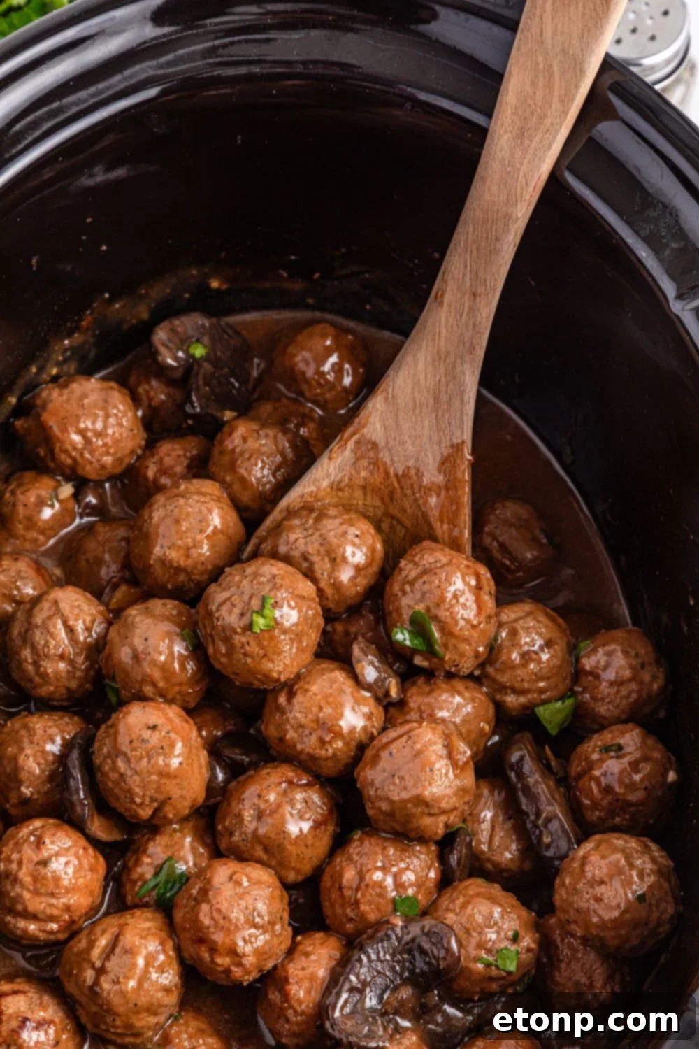 Comforting Slow Cooker Salisbury Steak Meatballs 18 Crock Pot Salisbury Steak Meatballs in the crock pot with a wooden spoon stuck in the pan