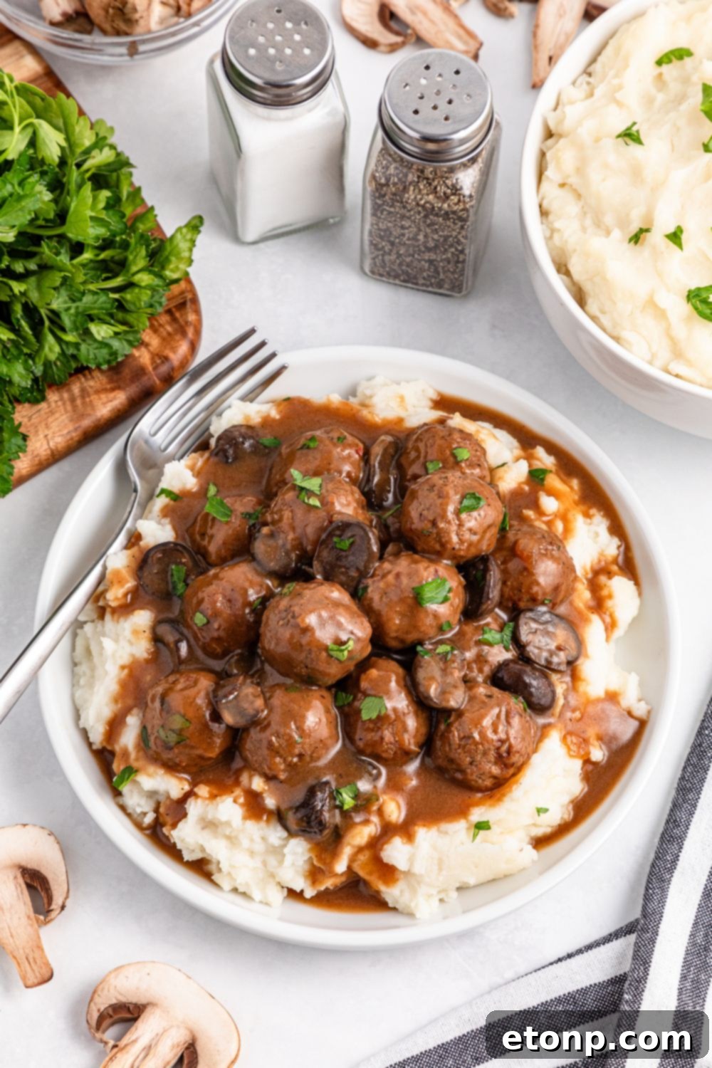 Comforting Slow Cooker Salisbury Steak Meatballs 6 Crock Pot Salisbury Steak Meatballs on a plate with mashed potatoes under them with a fork on the side