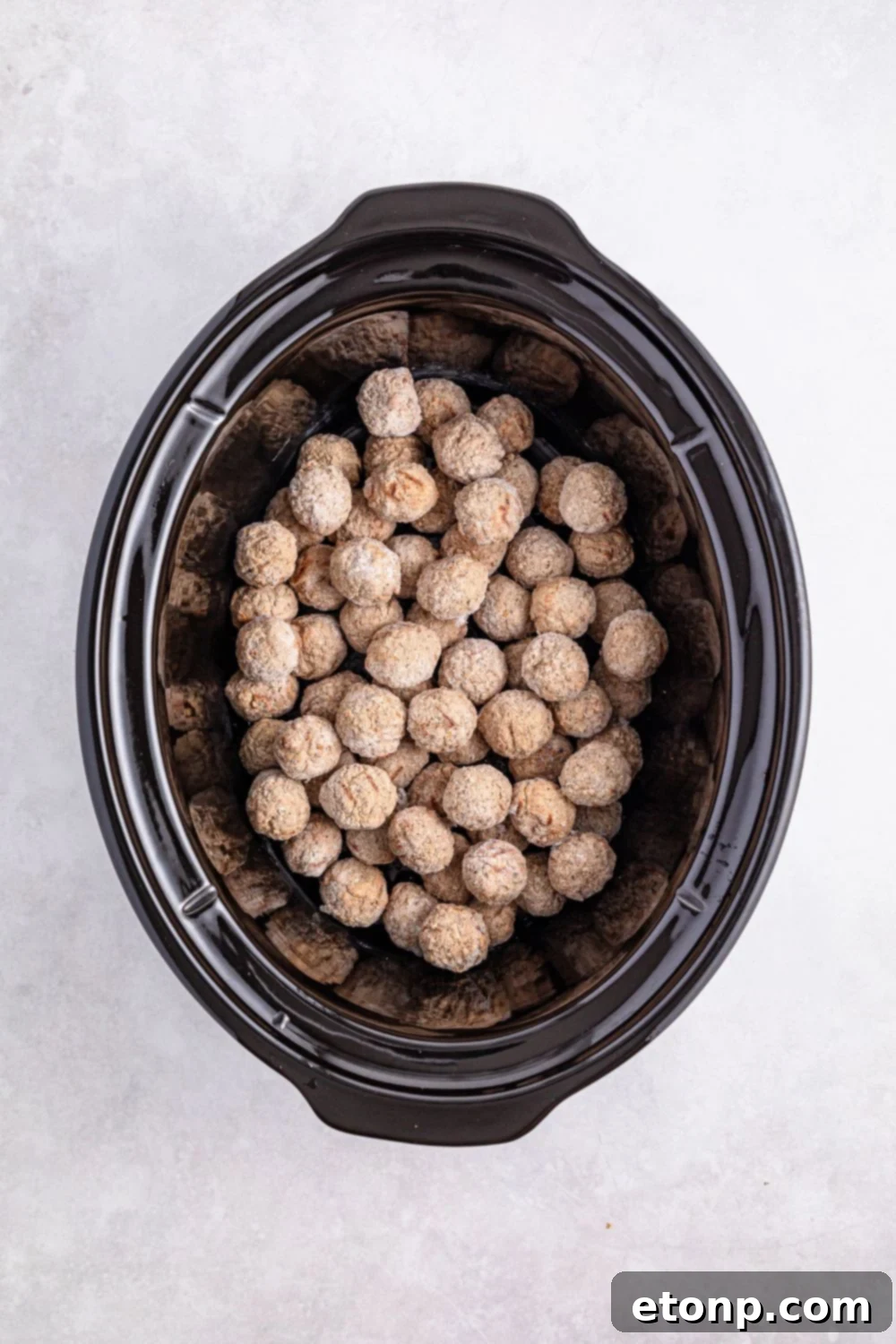 Comforting Slow Cooker Salisbury Steak Meatballs 8 frozen meatballs in a crockpot sitting on a table