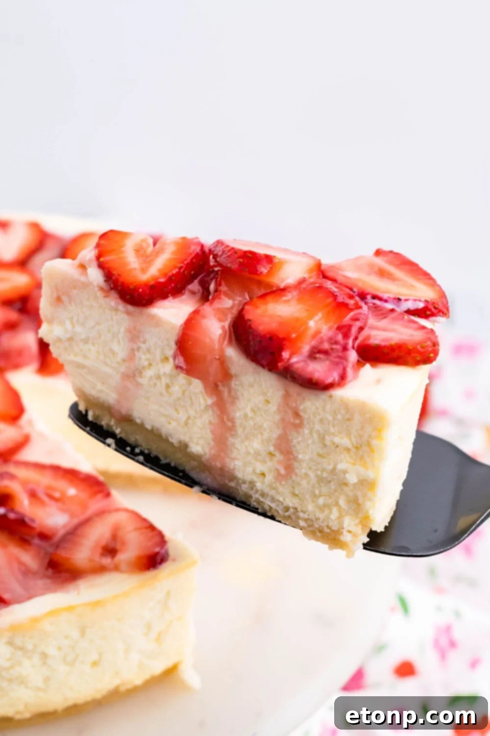 Keto Cheesecake with a slice being lifted off plate with a spatula 