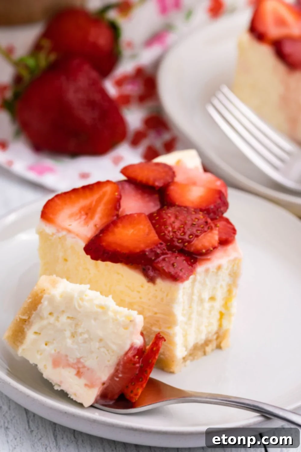 slice of keto cheesecake on plate with a bite of it on the side with a fork