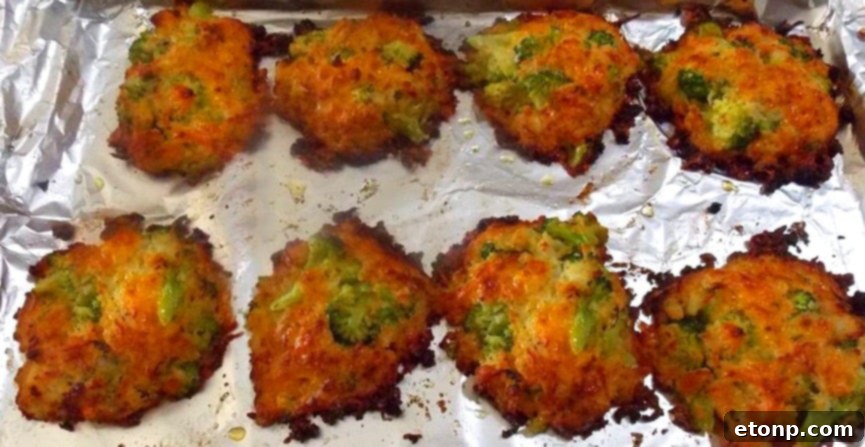 Close-up of golden-brown and perfectly crunchy cheesy broccoli patties on a baking sheet