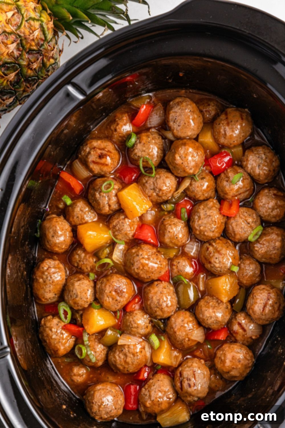 sweet and sour meatballs in a slow cooker on table