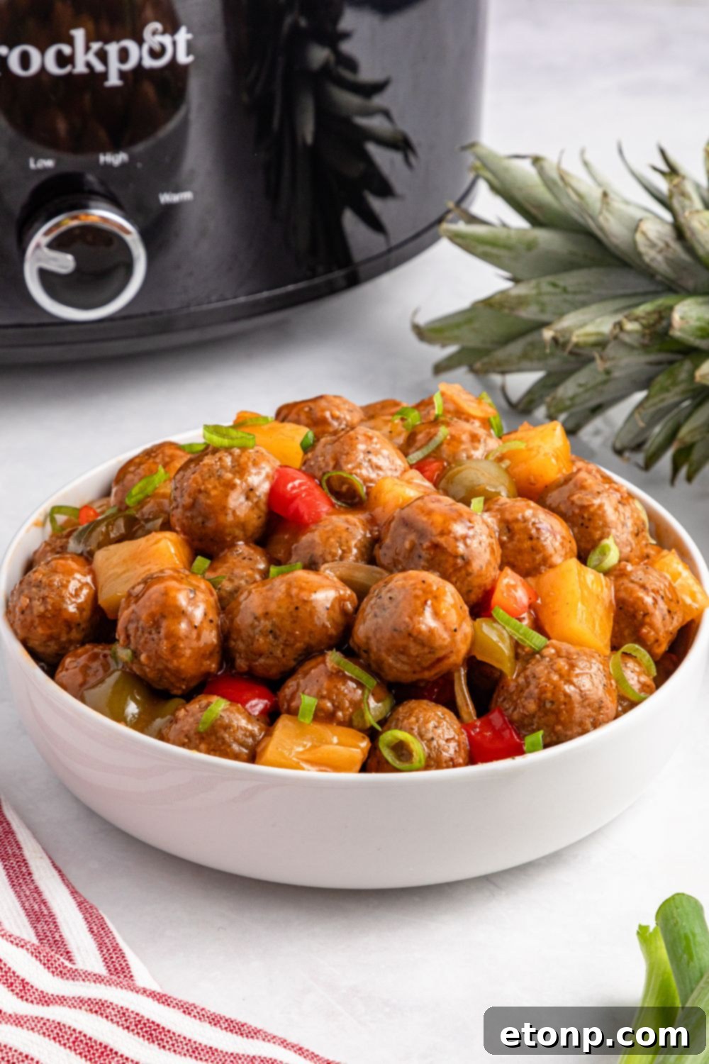 Crock Pot Sweet And Sour Meatballs in a white bowl on table 