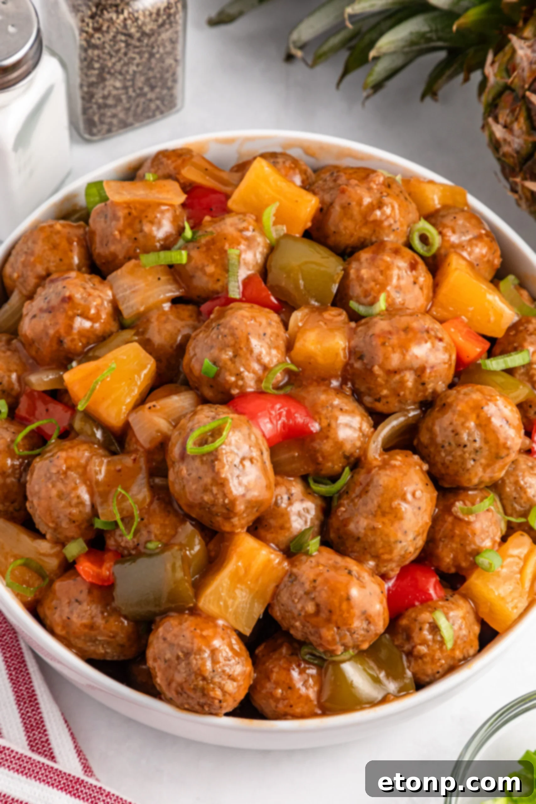 crock pot sweet and sour meatballs in a large white serving bowl