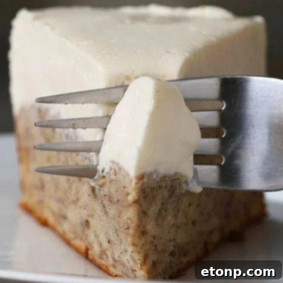 Slice of banana bread bottom cheesecake with a creamy topping