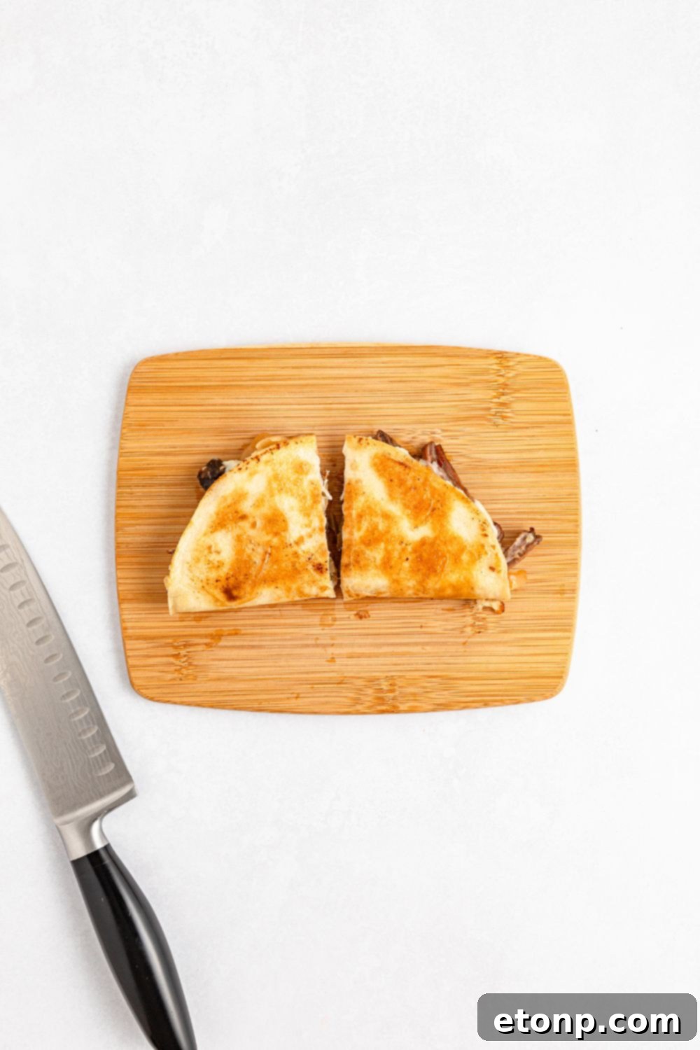 The Mississippi Pot Roast Remix 14 Mississippi Pot Roast Quesadilla on a cutting board with a slice in half