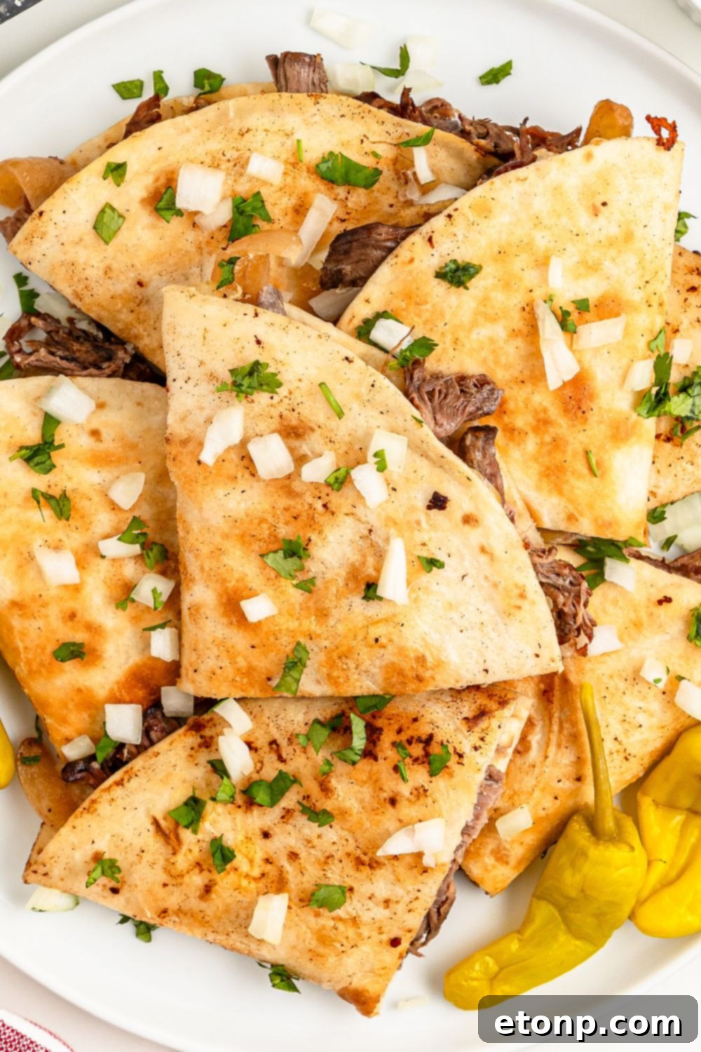 The Mississippi Pot Roast Remix 18 Mississippi Pot Roast Quesadillas spread out on table with some peppers