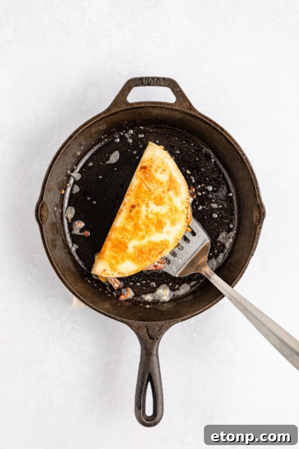 The Mississippi Pot Roast Remix 7 Mississippi Pot Roast Quesadillas in a skillet with a spatula under it
