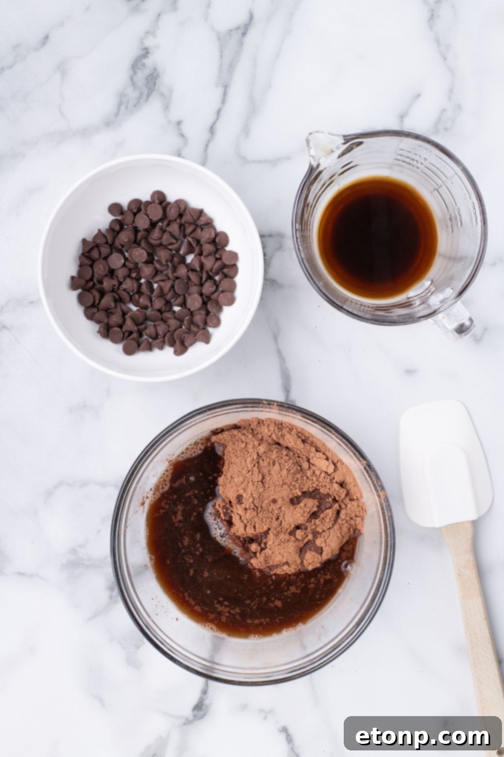cake batter in bowl with a small bowl of chocolate chips and coffee next to it on table 