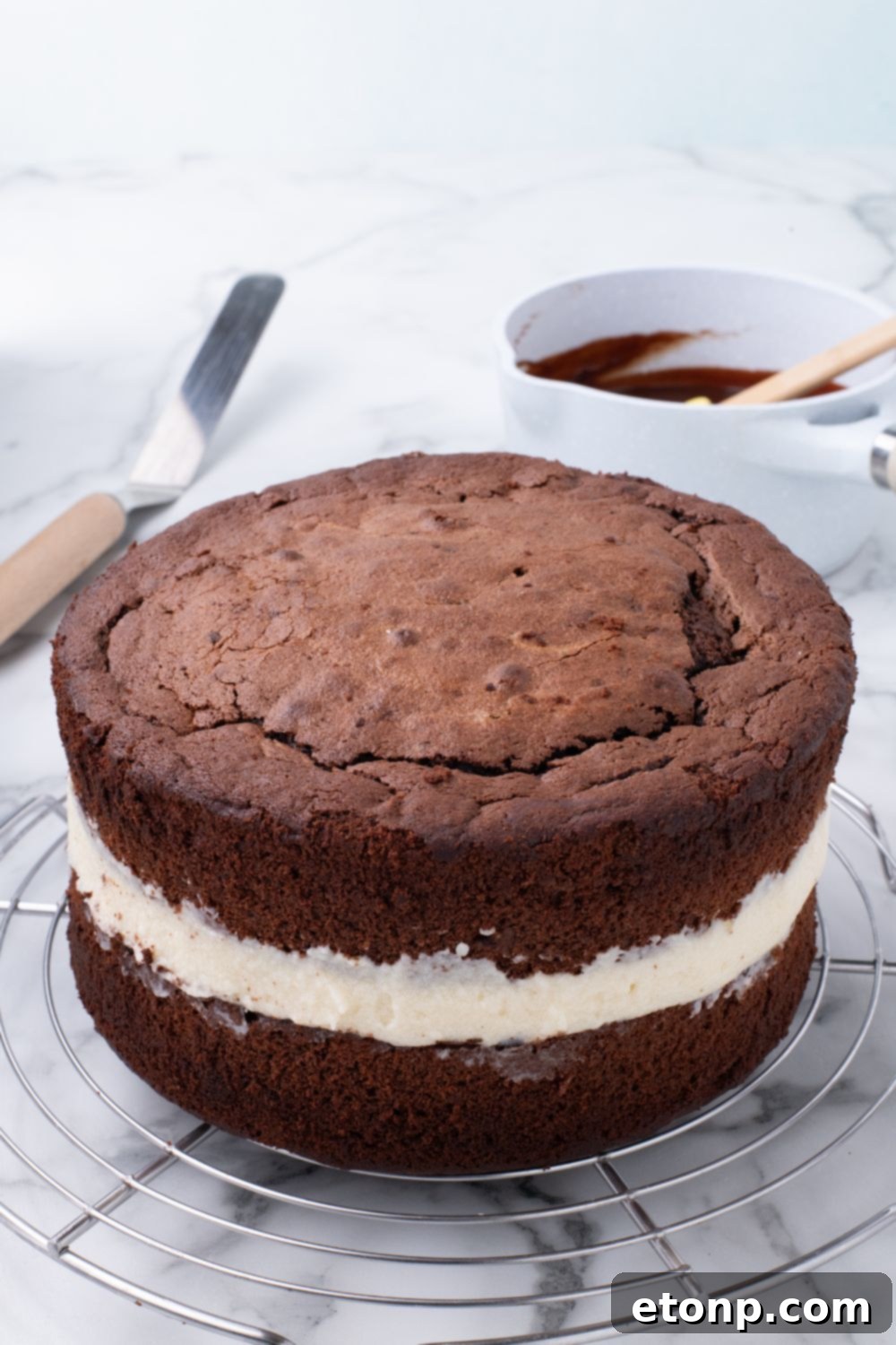 layered Ding Dong Cake that is unglazed sitting on tray, showing how to assemble the cake 