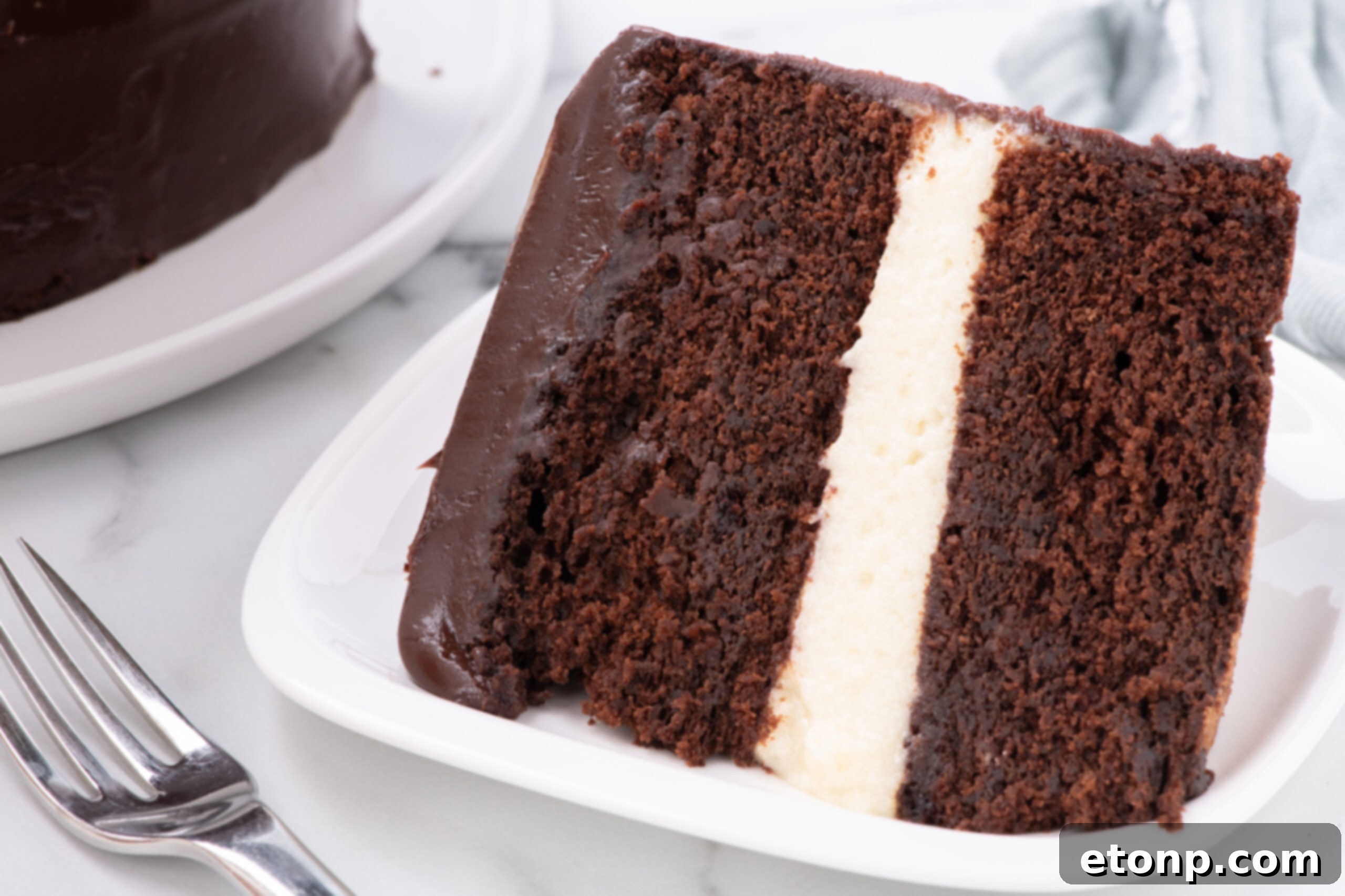 side view of Slice of Ding Dong Cake on a white plate with a pork on the side