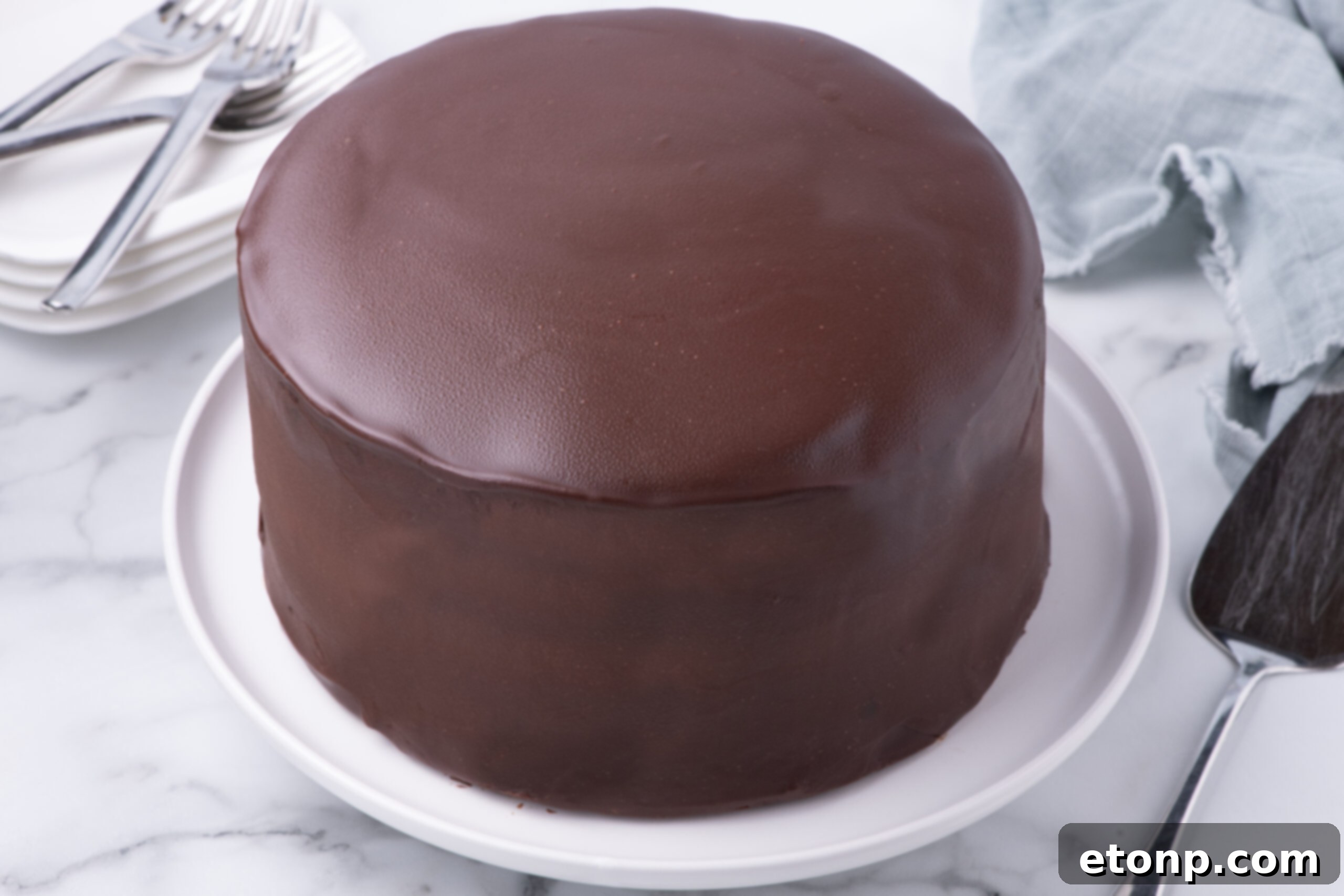 Whole uncut Ding Dong Cake on a white cake stand