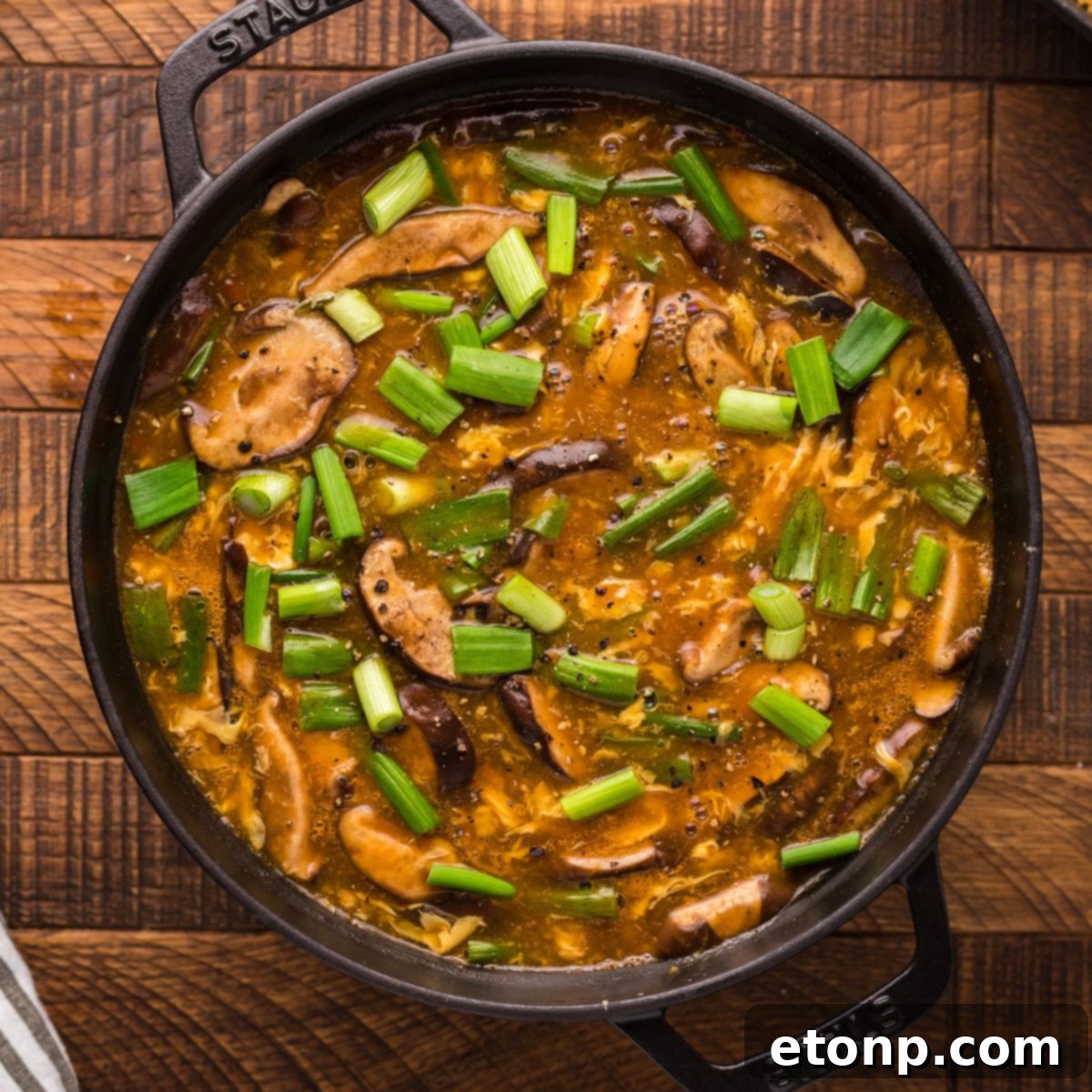 P.F. Chang's Hot and Sour Soup simmering in a pan on a rustic wooden table, ready to be served