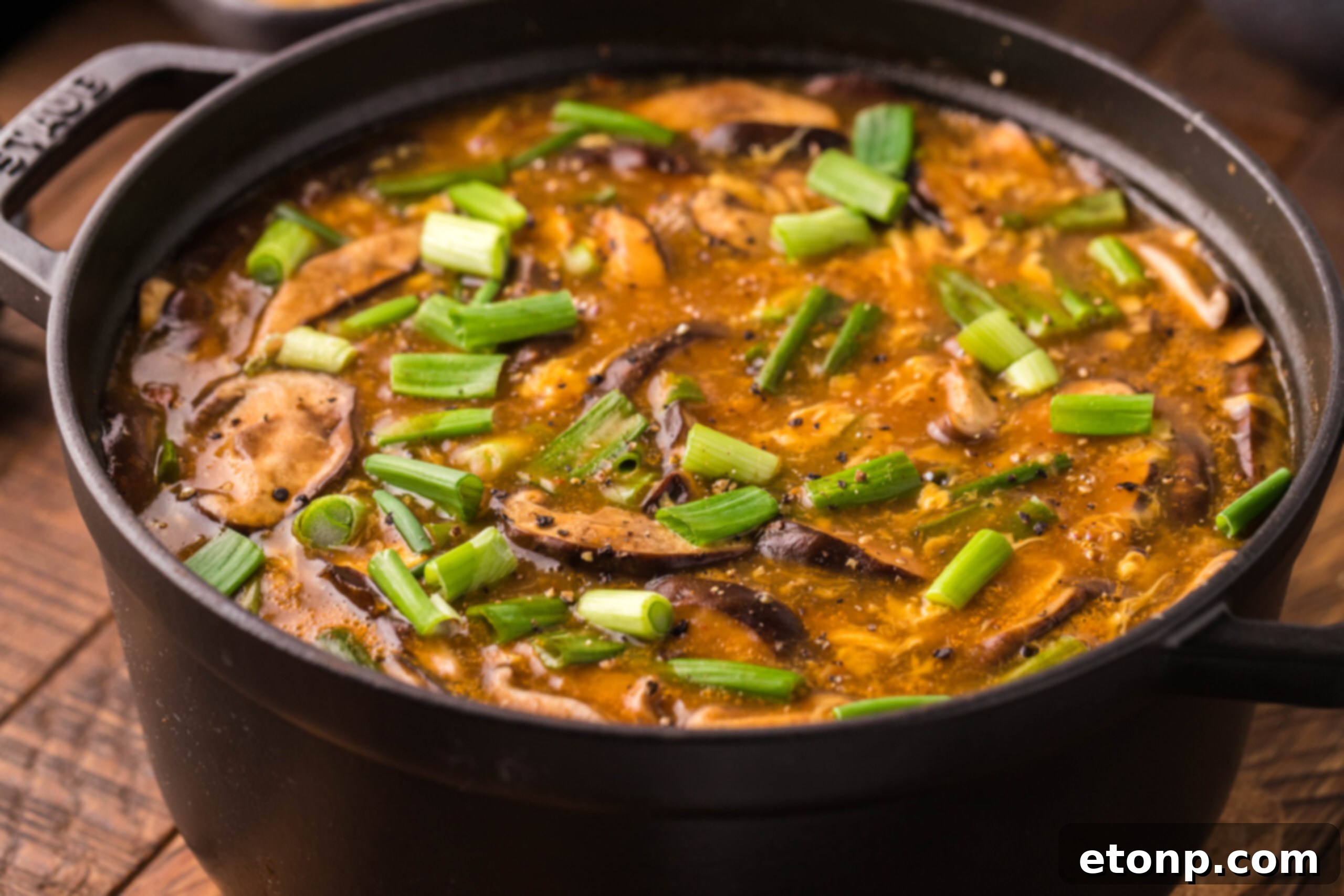Close-up side view of P.F. Chang's Hot and Sour Soup in a large, steaming pot