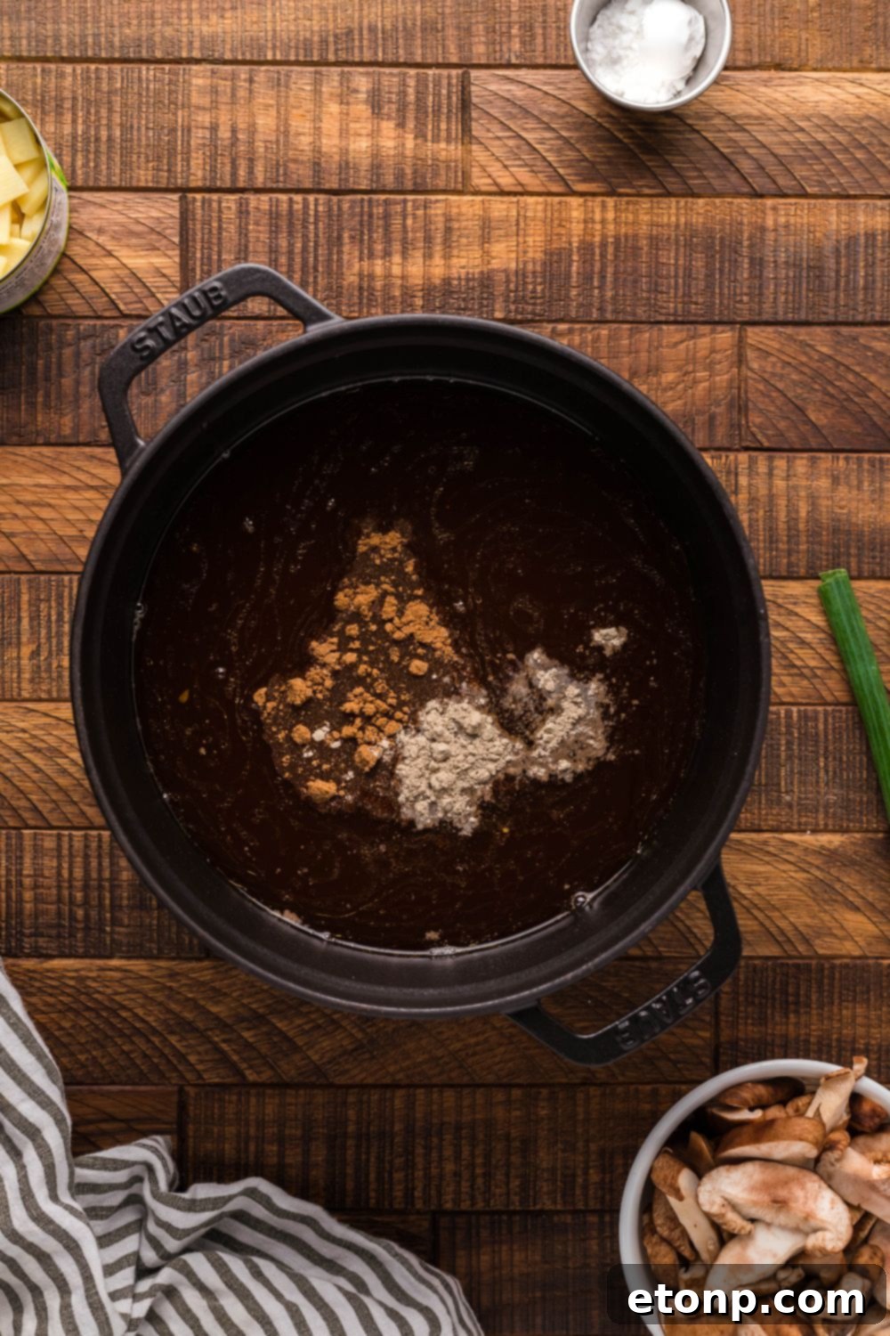 Rich broth and a variety of spices being combined in a pot for P.F. Chang's Hot and Sour Soup