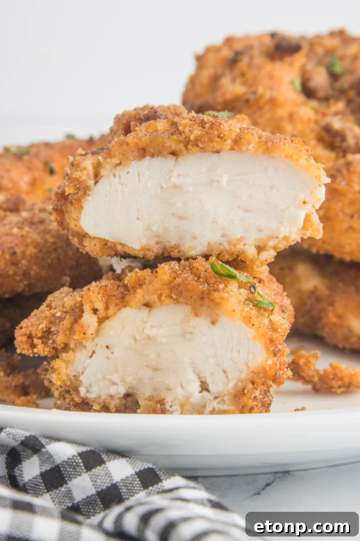 Air Fryer Chicken Tenders  cut open on a white plate showing the cooked inside