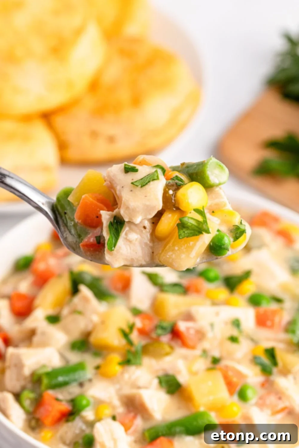 Slow Cooker Chicken Pot Pie in a bowl with a spoon scooping out of it 