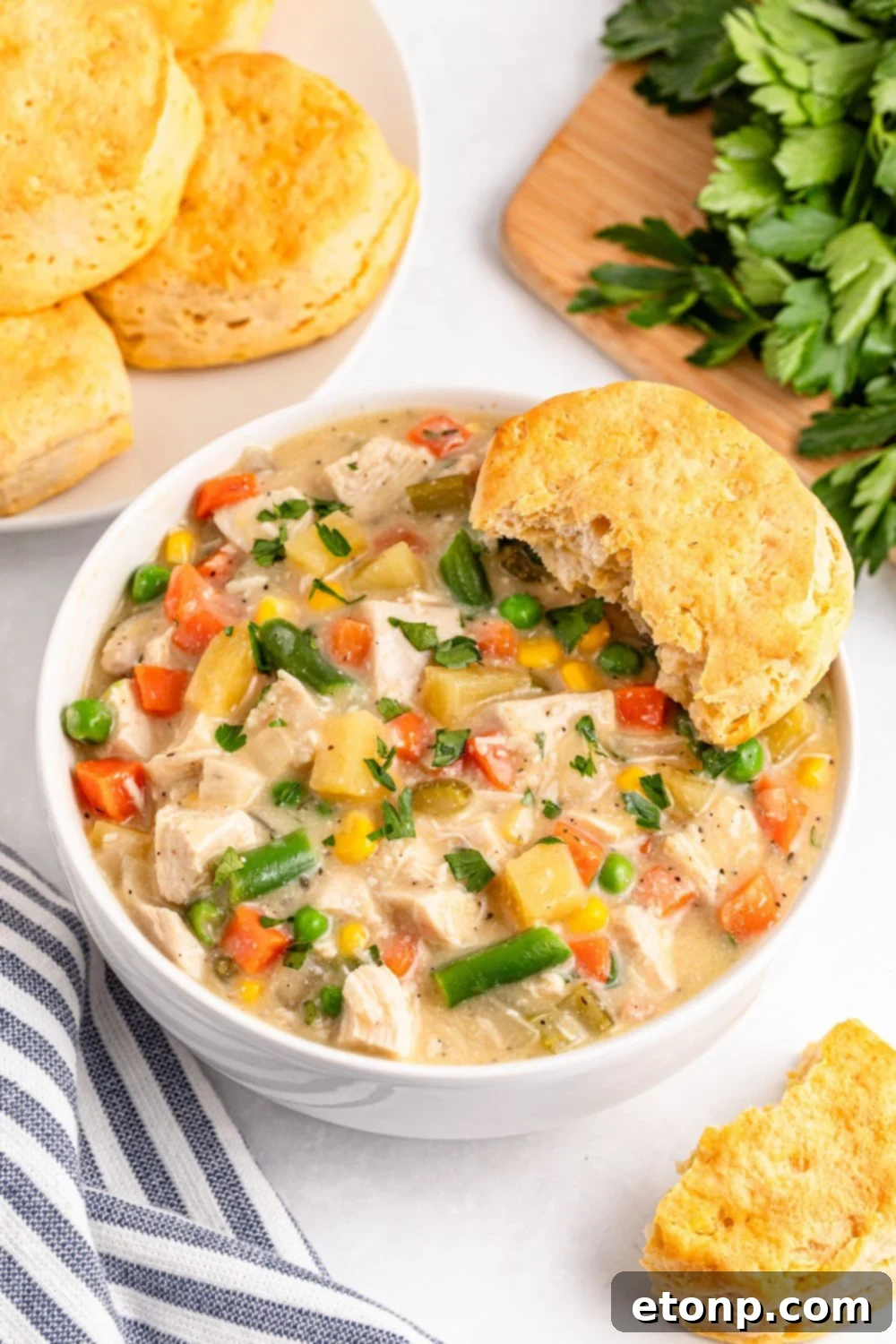 Slow Cooker Chicken Pot Pie in a bowl with biscuits on the side 