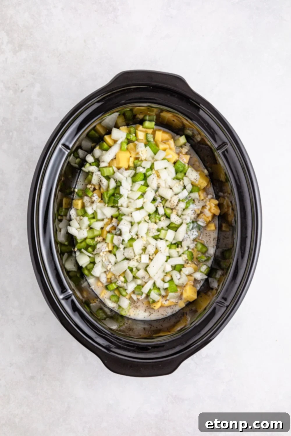 raw slow cooker pot pie ingredients in slow cooker on table