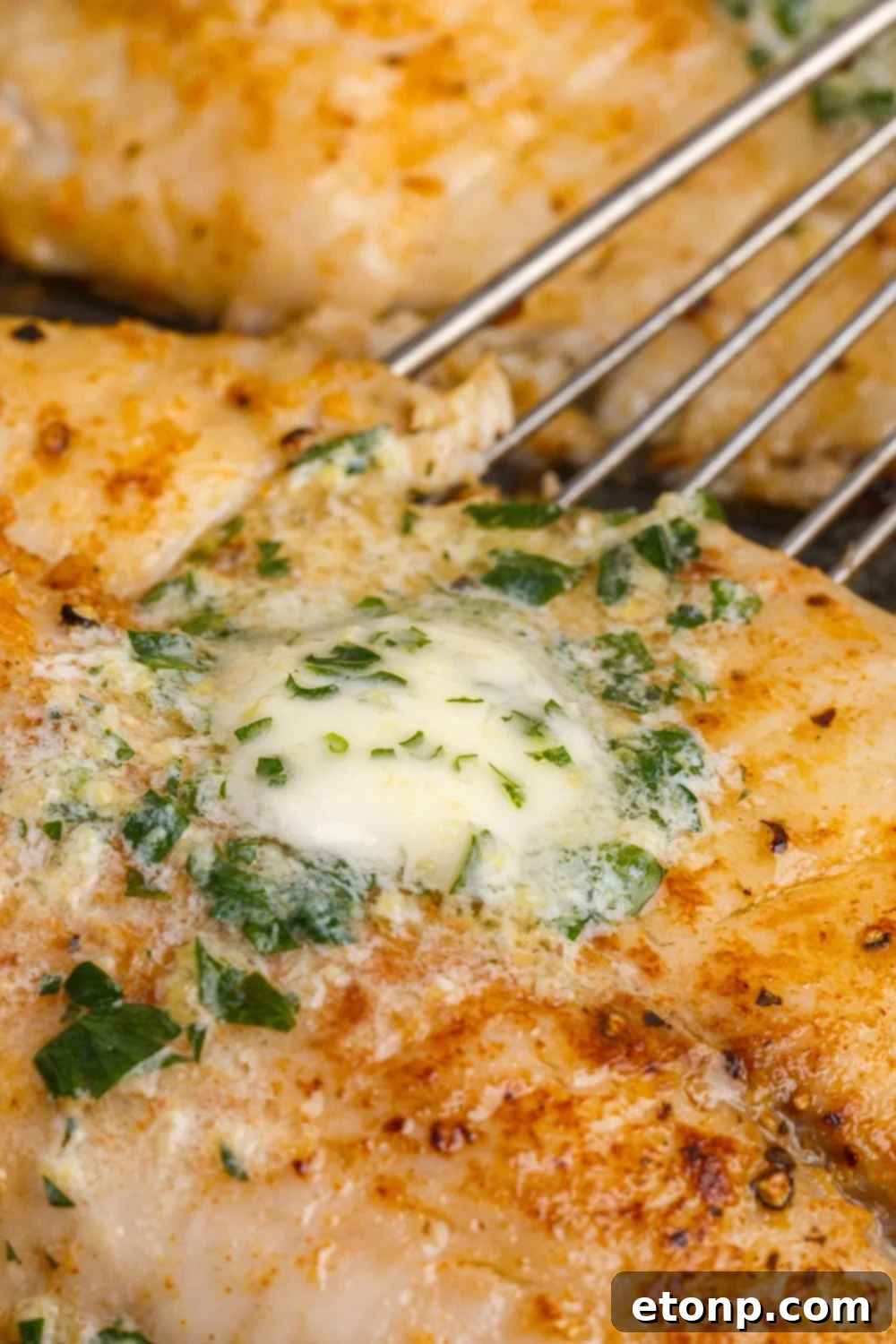 Pan Fried Tilapia with a skillet on side scooping it up