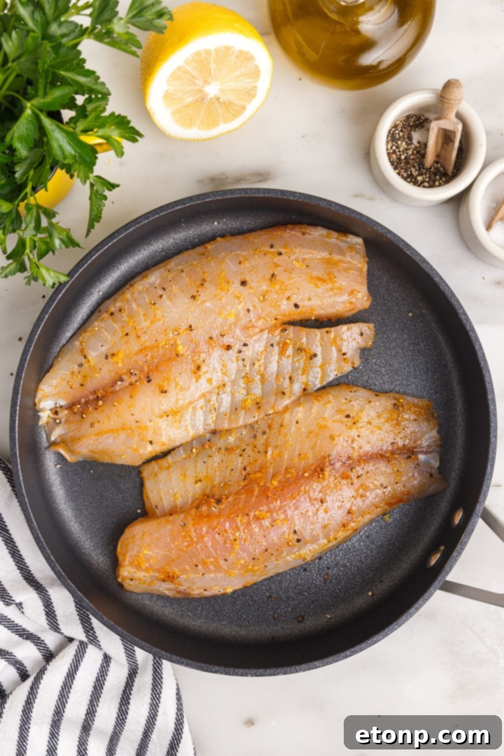 seasoned tilapia in pan, raw.