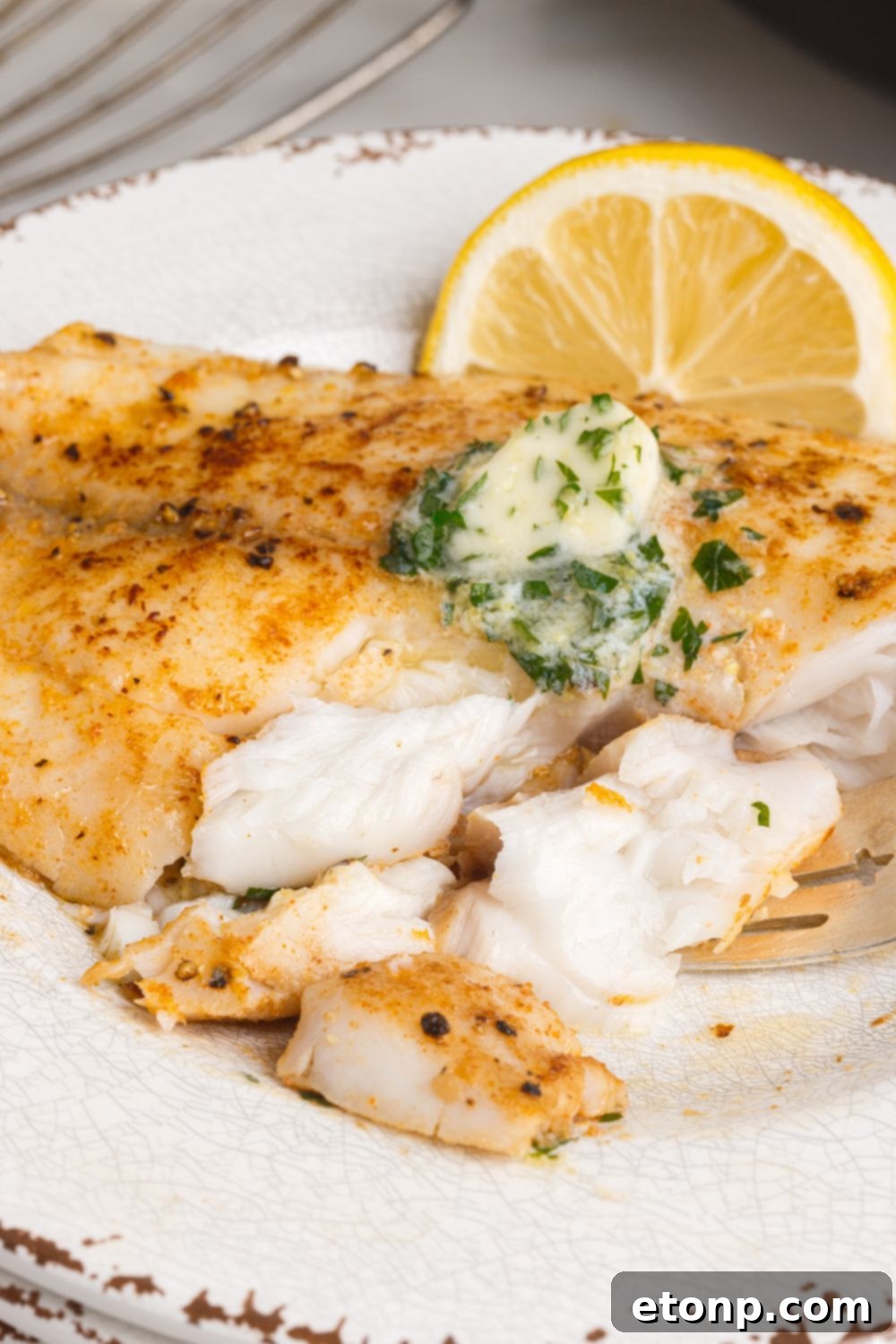 Pan Fried Tilapia on plate with pieces cut out of it