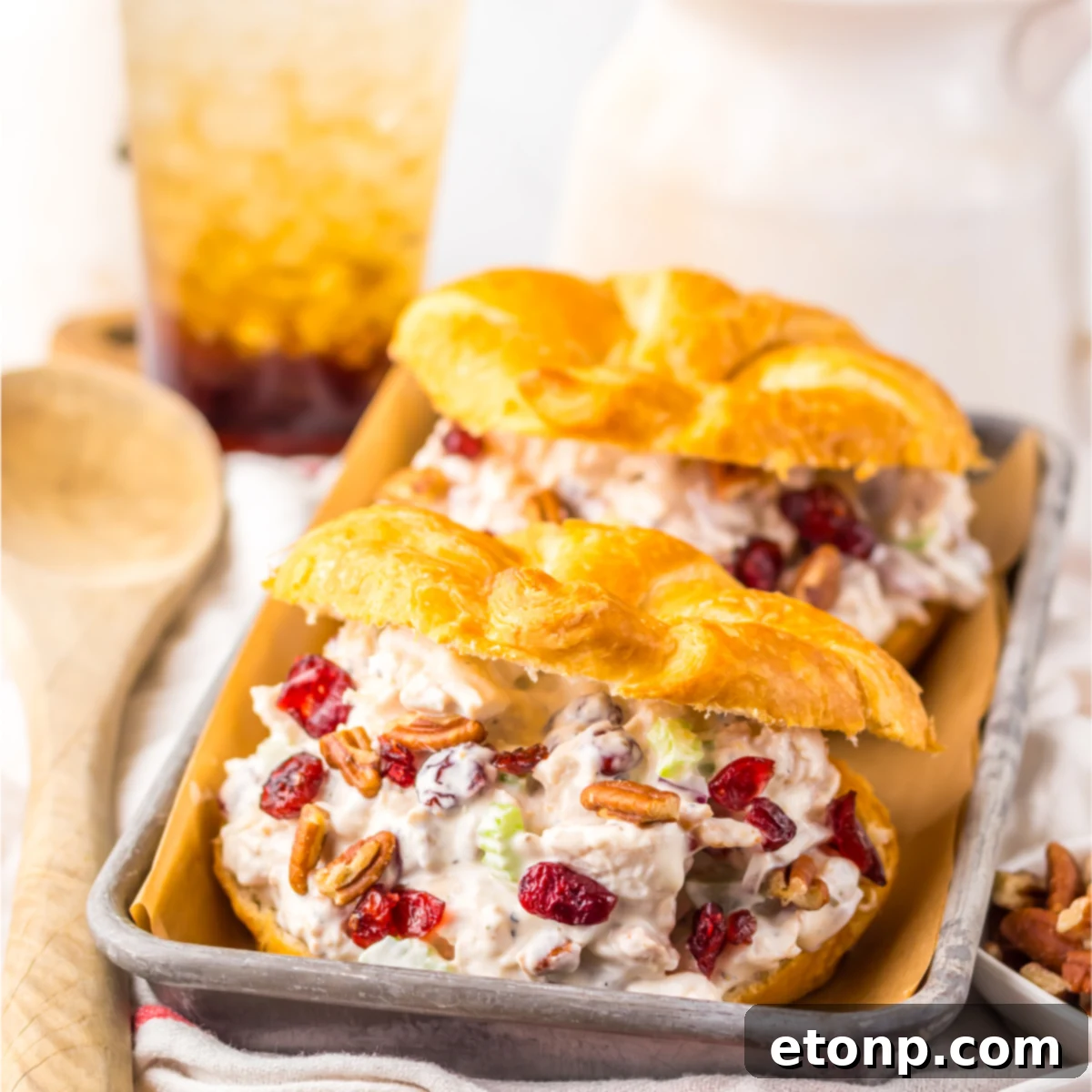 Close up of the chicken salad croissant filling topped with cranberries and pecans. 