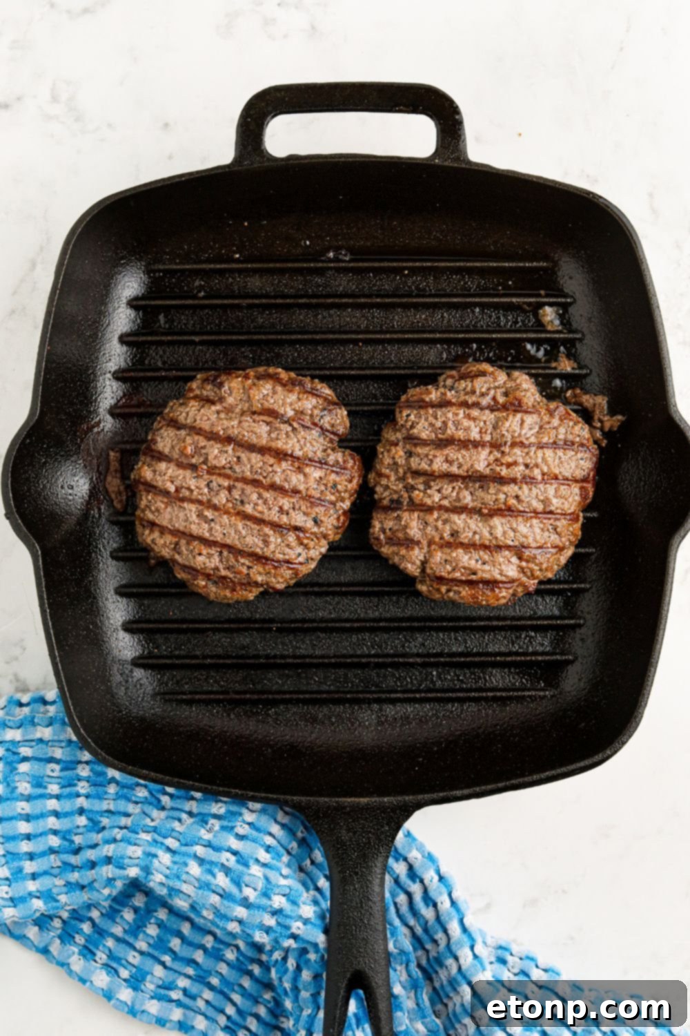 grill pan with cooked hamburgers in pan sitting on table 