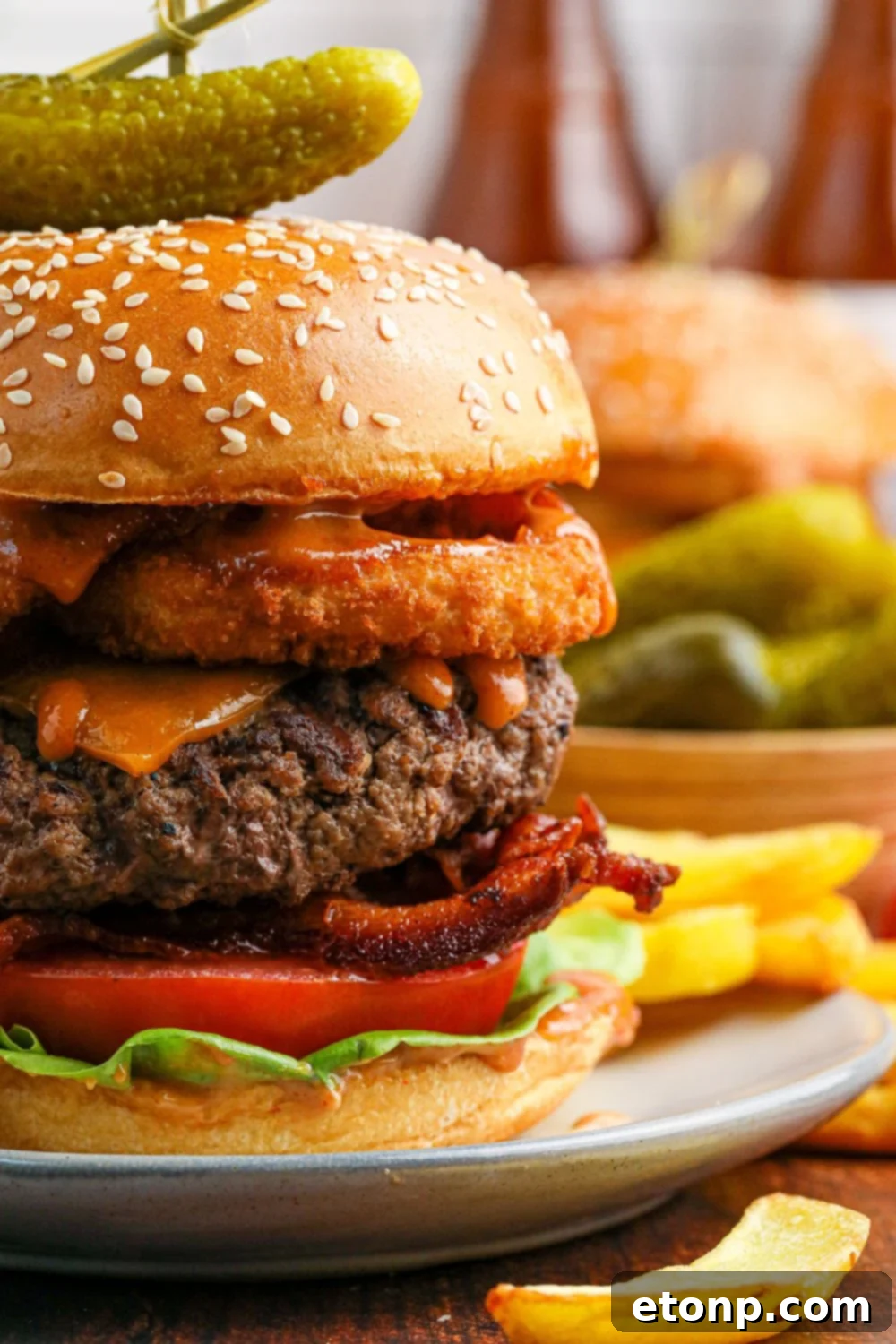 side view of a Cowboy Burger on a plate to see all the layers in the burger 
