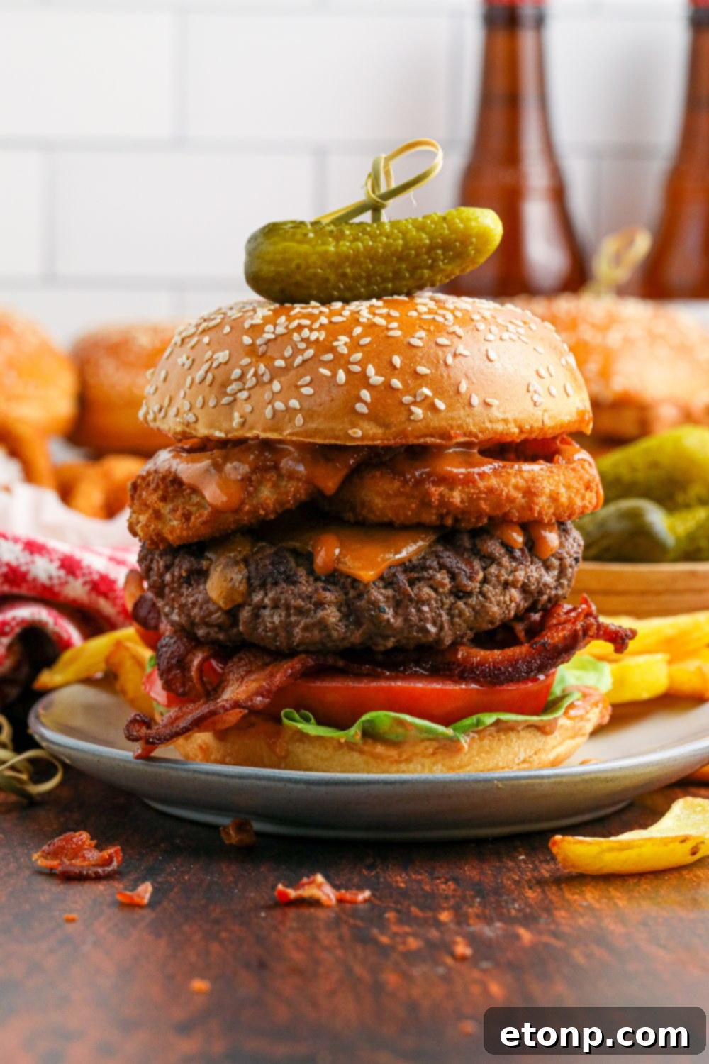 Cowboy Burger on plate with a pickle and toothpick on top 