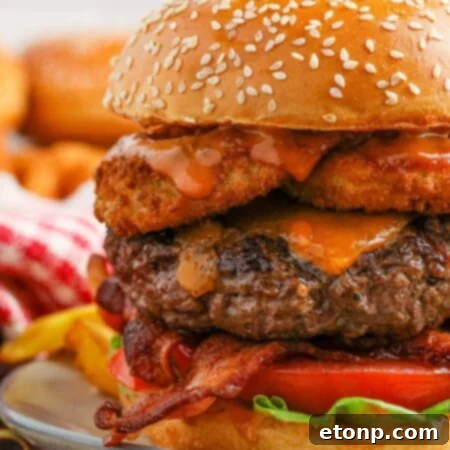 Close up view of a cowboy burger on a plate with a pickle on top