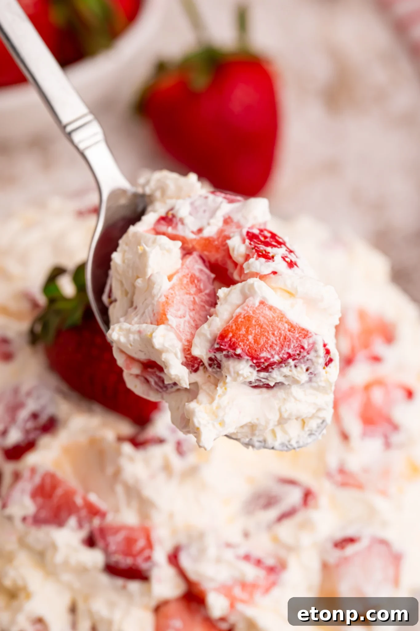 view of the strawberry cheesecake salad bite on a spoon
