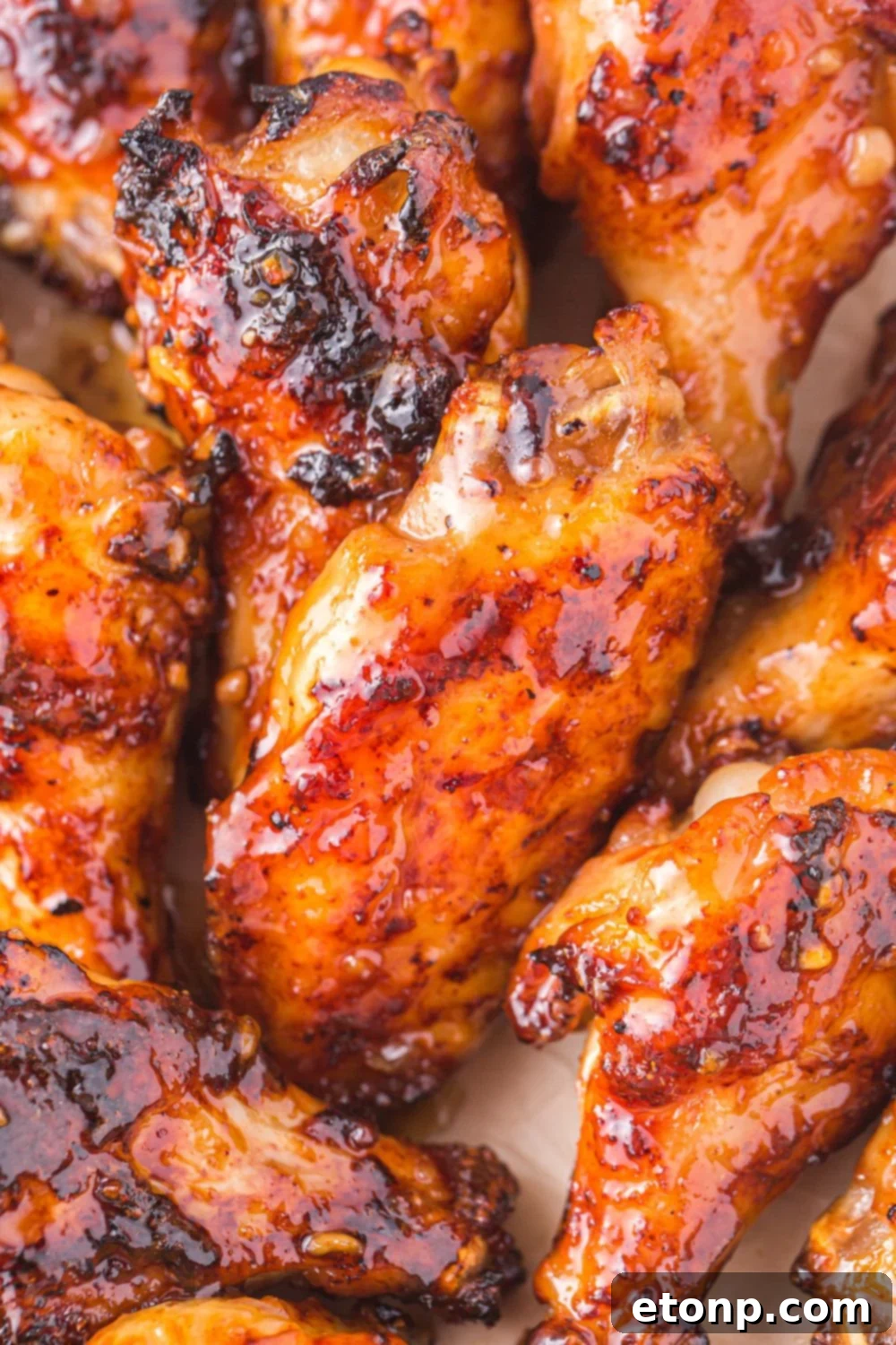 The Best Crispy Honey Garlic Air Fryer Chicken Wings 16 Extremely close-up view of a perfectly charred Air Fryer Honey Garlic Chicken Wing, highlighting its crispy texture and caramelized glaze.
