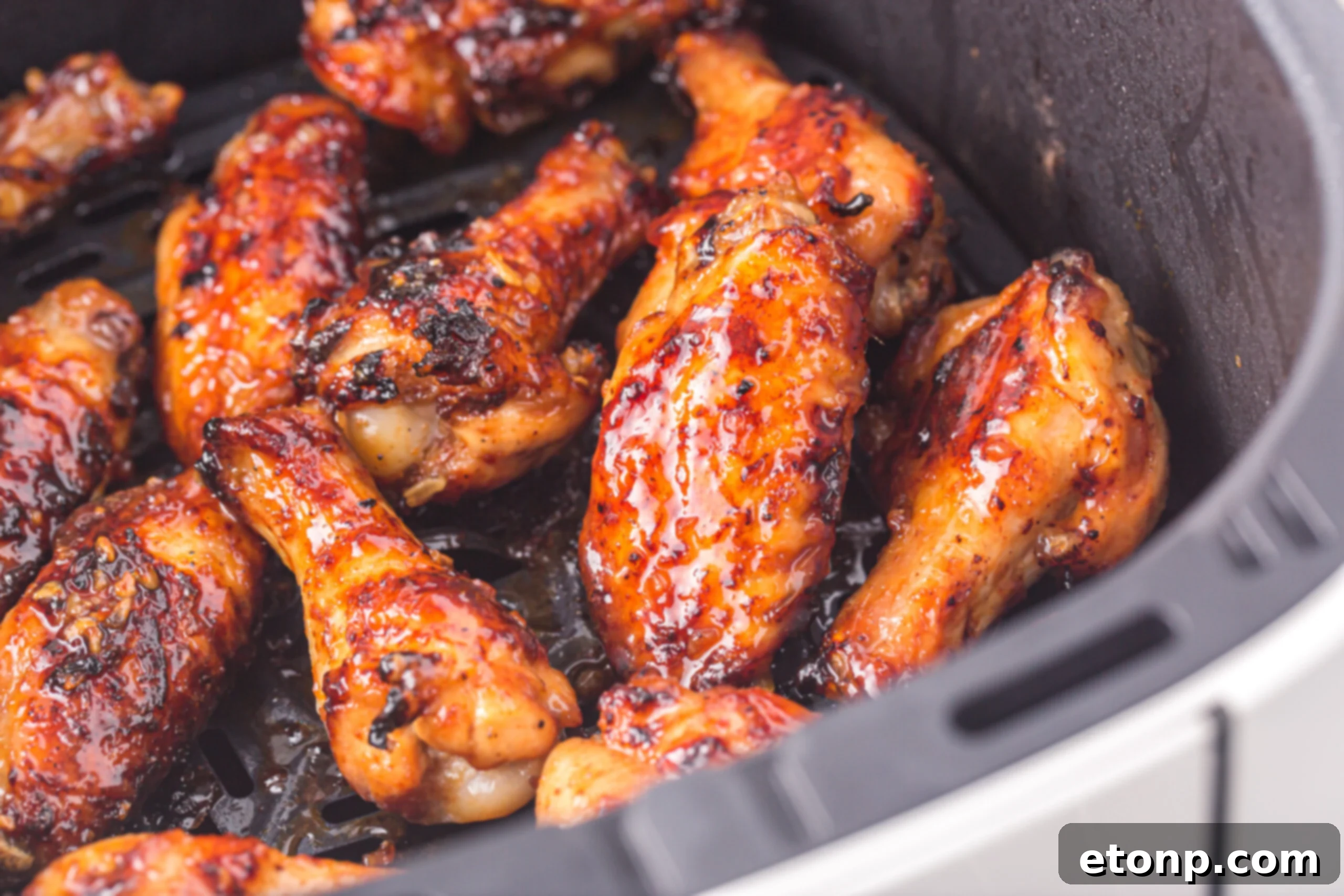 The Best Crispy Honey Garlic Air Fryer Chicken Wings 19 An air fryer basket filled with perfectly cooked and glazed Air Fryer Honey Garlic Chicken Wings.