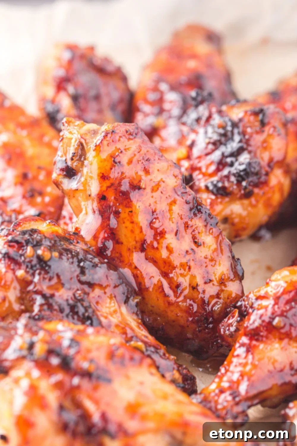The Best Crispy Honey Garlic Air Fryer Chicken Wings 20 Air fried chicken wings with a beautiful, sticky glaze spread out on a table, highlighting their appetizing sheen.