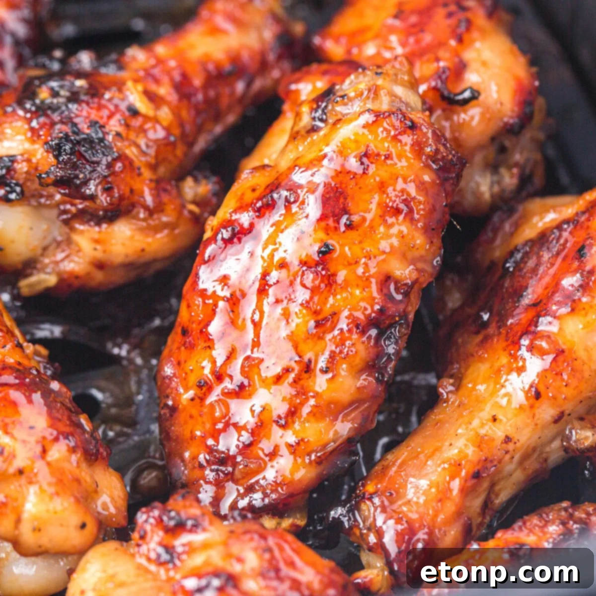 The Best Crispy Honey Garlic Air Fryer Chicken Wings 3 Air Fryer Honey Garlic Chicken Wings cooking inside an air fryer basket, showing their developing crispiness.