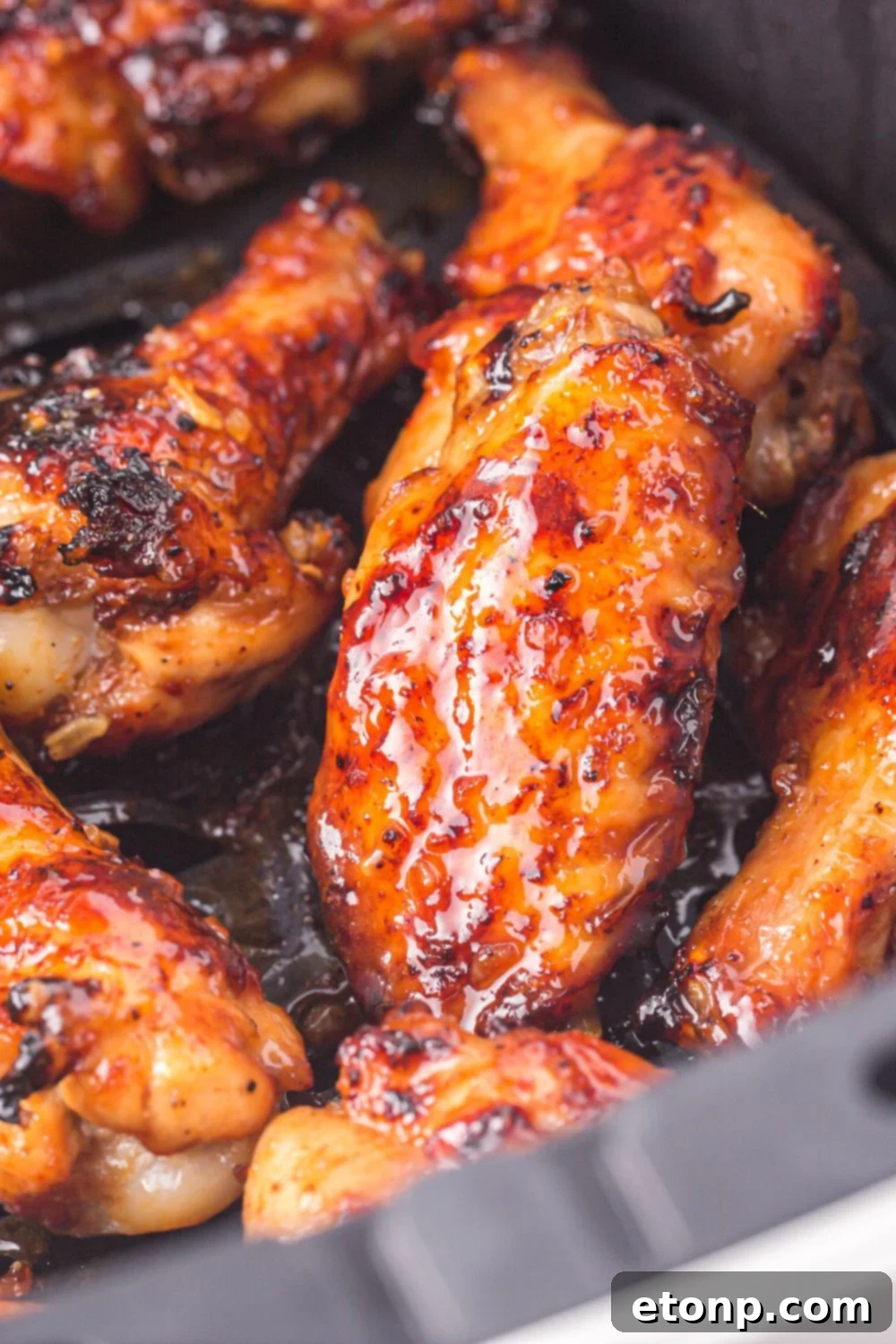 The Best Crispy Honey Garlic Air Fryer Chicken Wings 22 A close-up view of perfectly air fried crispy chicken wings, showing their golden skin texture.