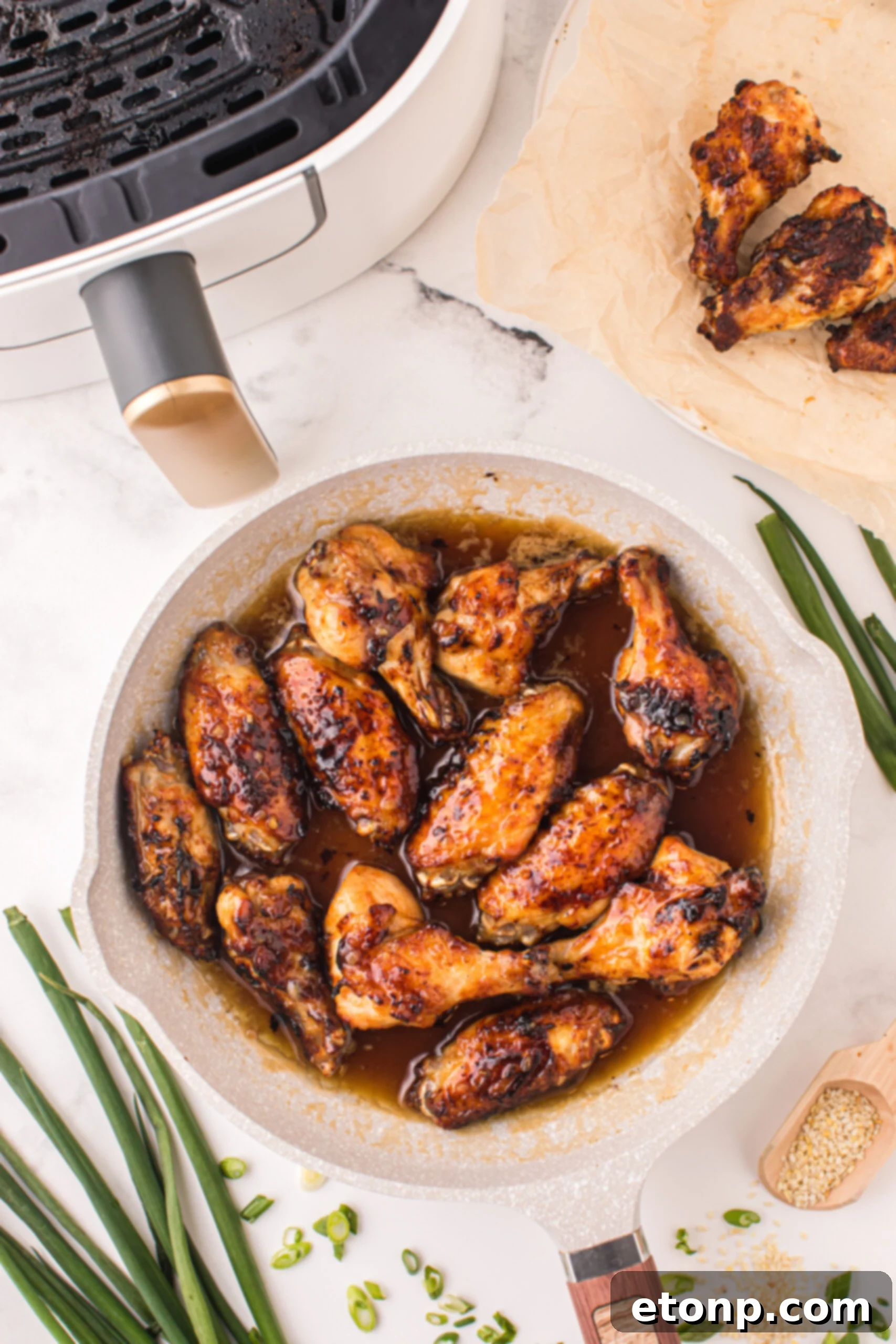 The Best Crispy Honey Garlic Air Fryer Chicken Wings 6 Air Fryer Honey Garlic Chicken Wings glistening with glaze in a skillet, ready to be served.