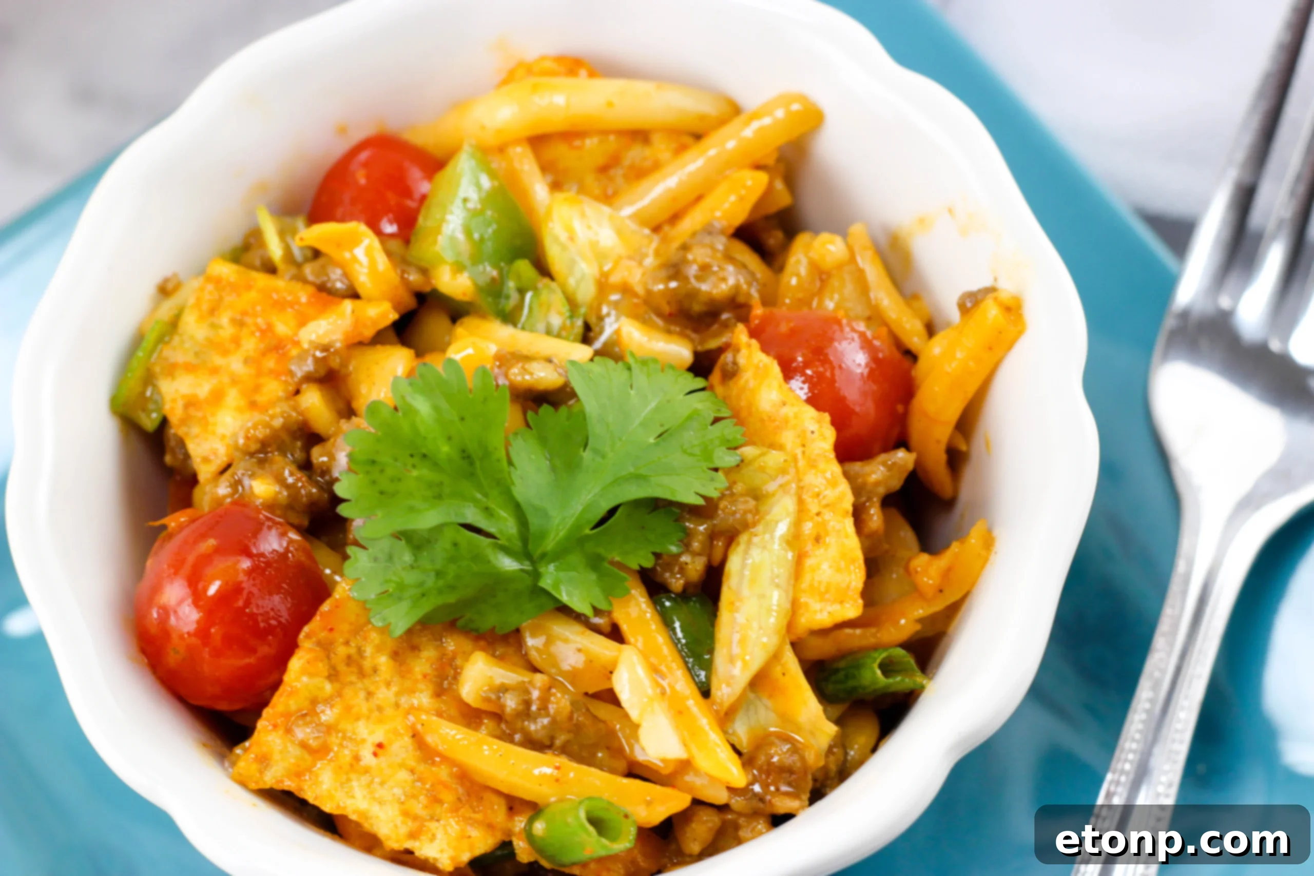 A generous scoop of Doritos Taco Pasta Salad being dished out, emphasizing its appealing textures and colors, suggesting its readiness for enjoyment.