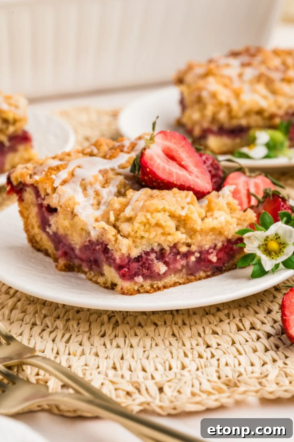 Fresh Strawberry Coffee Cake 12 Two plates each holding a slice of Strawberry Coffee Cake, garnished with fresh berries and forks, suggesting an inviting dessert experience.