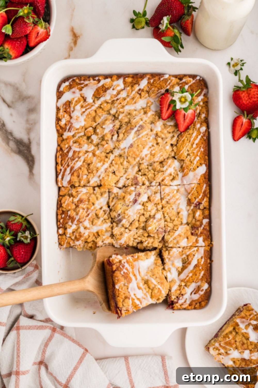 Fresh Strawberry Coffee Cake 5 A full Strawberry Coffee Cake in a baking pan with one slice already removed, highlighting the inviting texture and rich strawberry layer within.